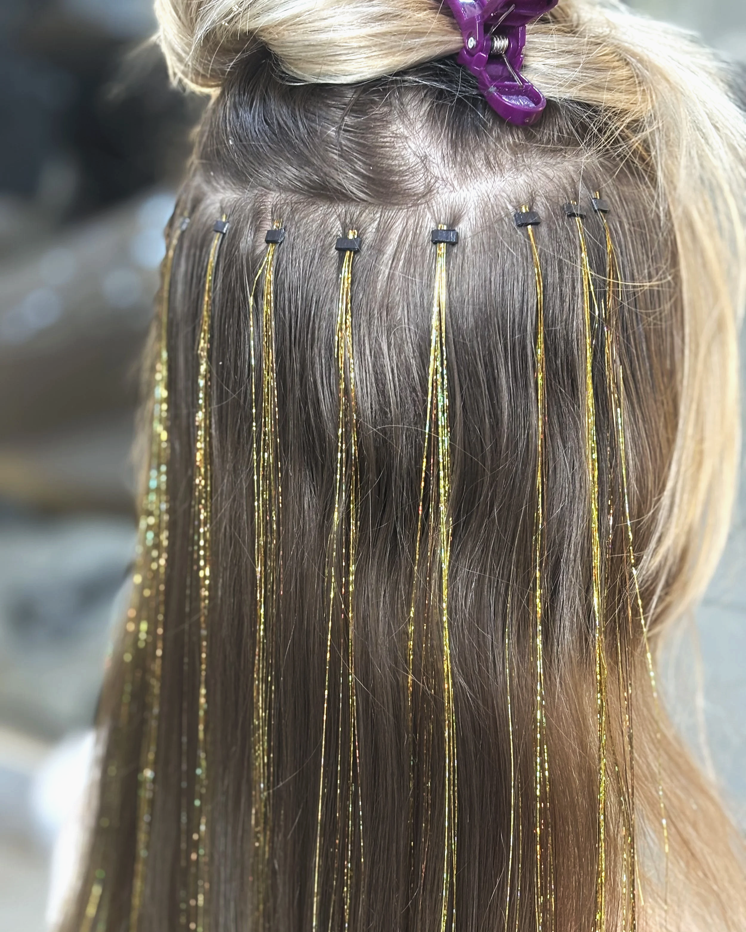 Hair being coloured or highlighted, with sections separated and foil or clips holding the hair in place. Hair Colouring service.