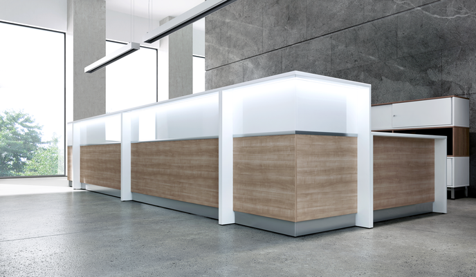 Modern reception desk with white top and wood panel sides in a bright office space