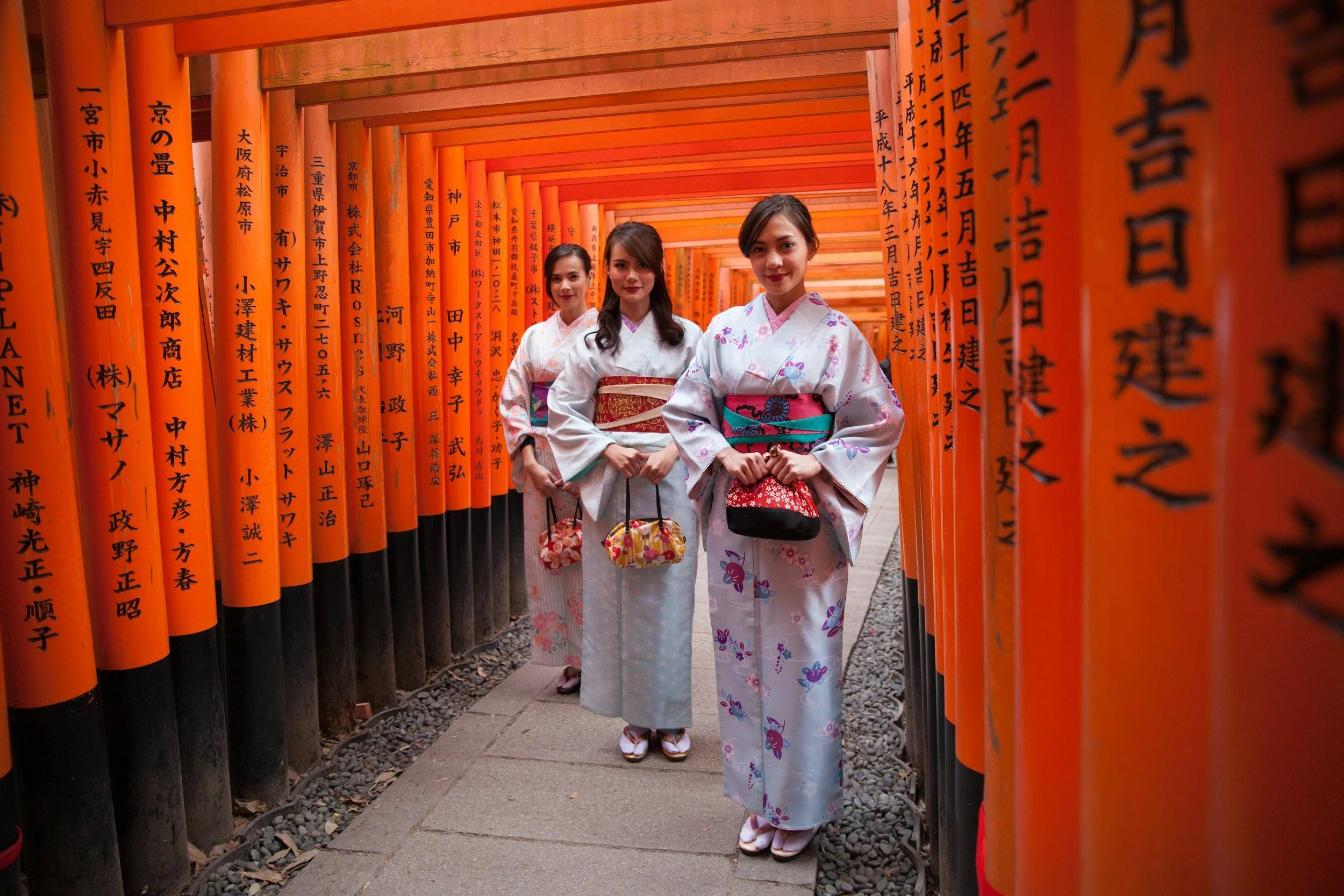 Travelers in kimono walking through shrine gates on a private tour in Japan