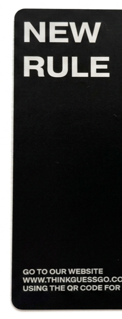 Black sign with white text that says 'NEW RULE' and instructions to visit a website and use a QR code.