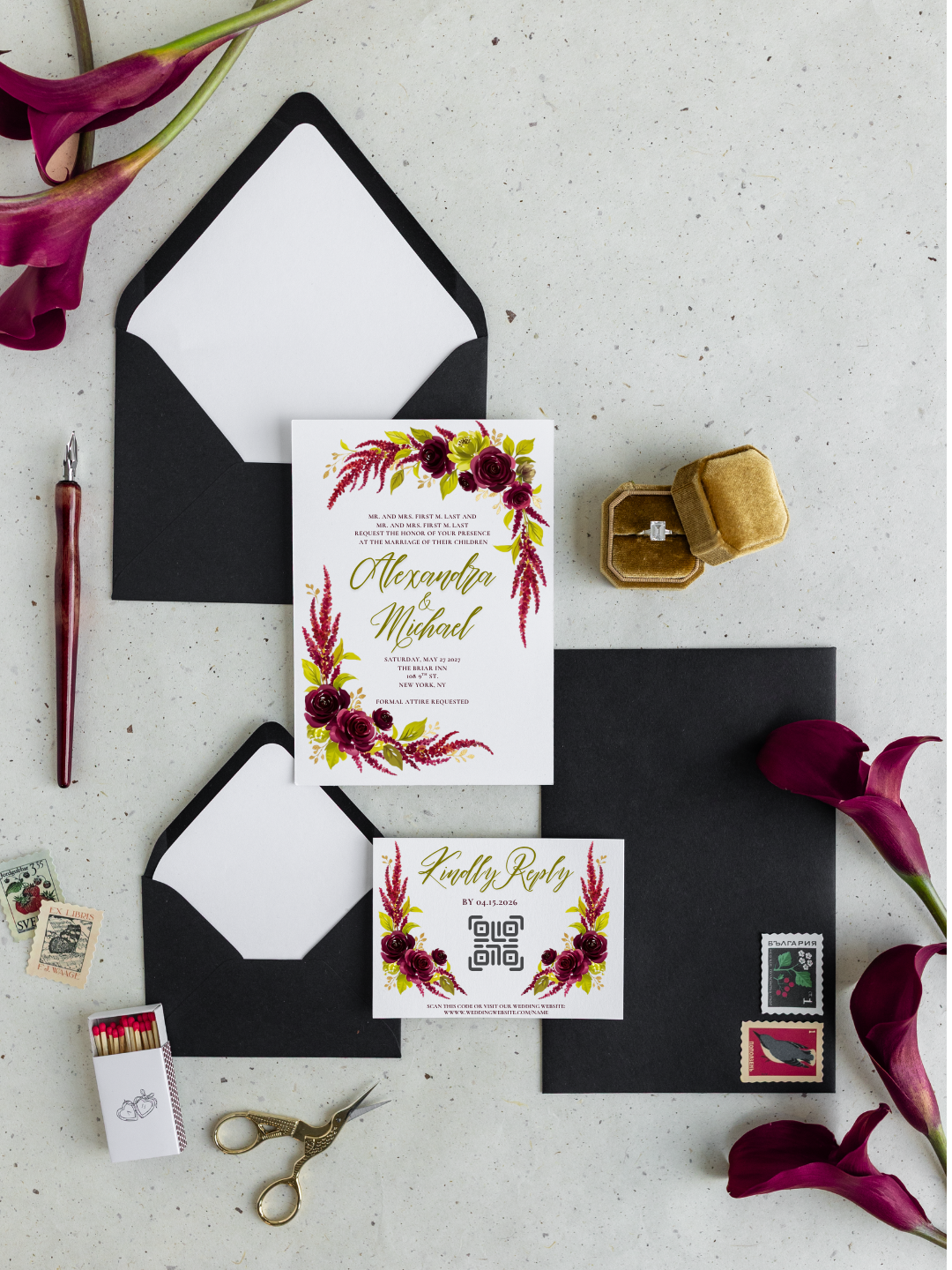 Wedding invitation suite with floral design, black envelopes, RSVP card, vintage rings box, stamps, matches, and pink calla lilies on a gray surface.