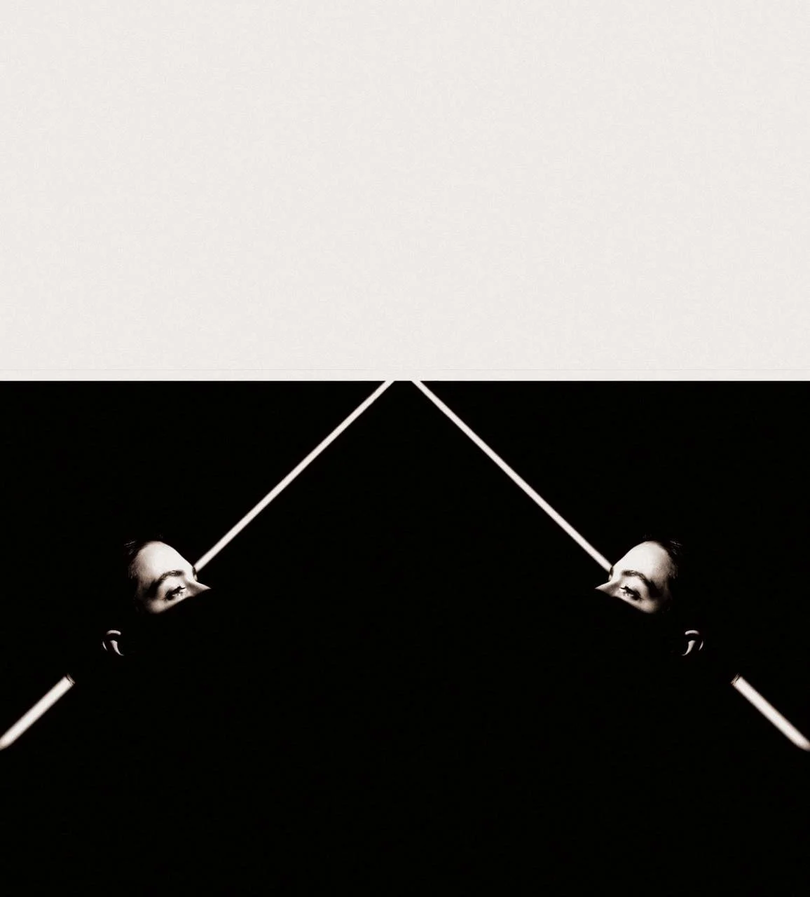 A mirrored photo of a person's face with only their eyes visible, set against a black background with diagonal white lines creating a symmetrical pattern.