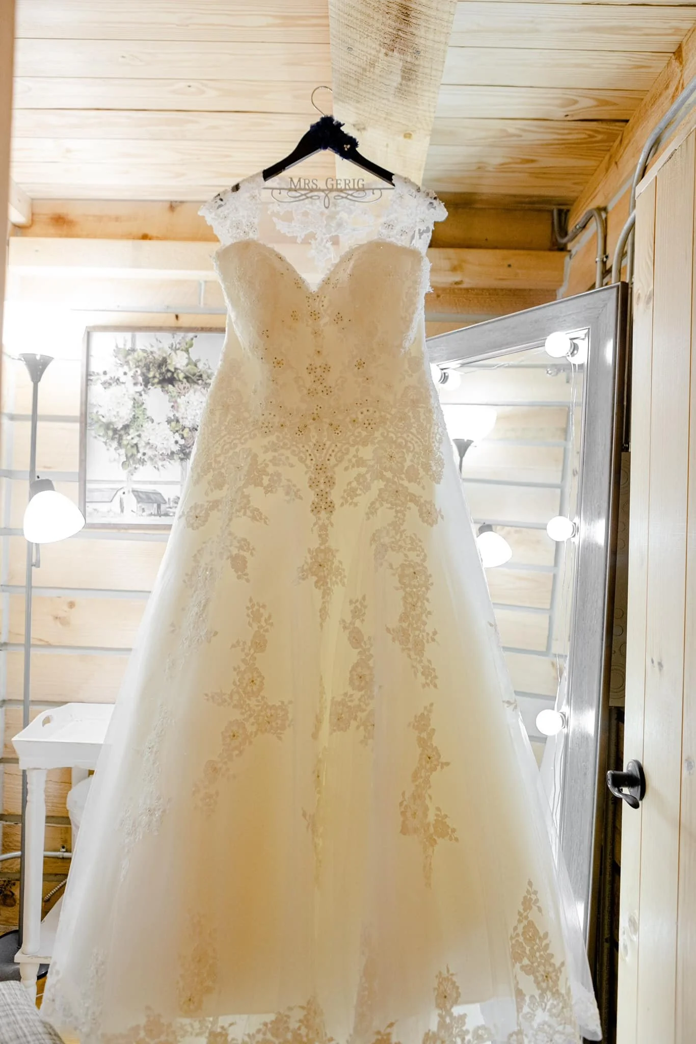 A wedding dress hangs in the cozy and well-fashioned bridal suite.