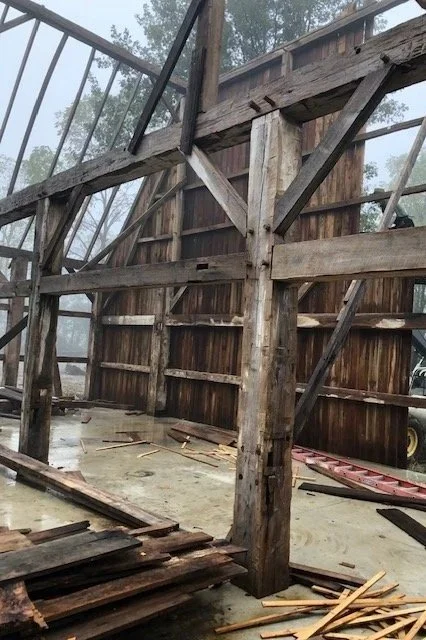 Wooden structure under construction with beams and planks inside a partially built building.