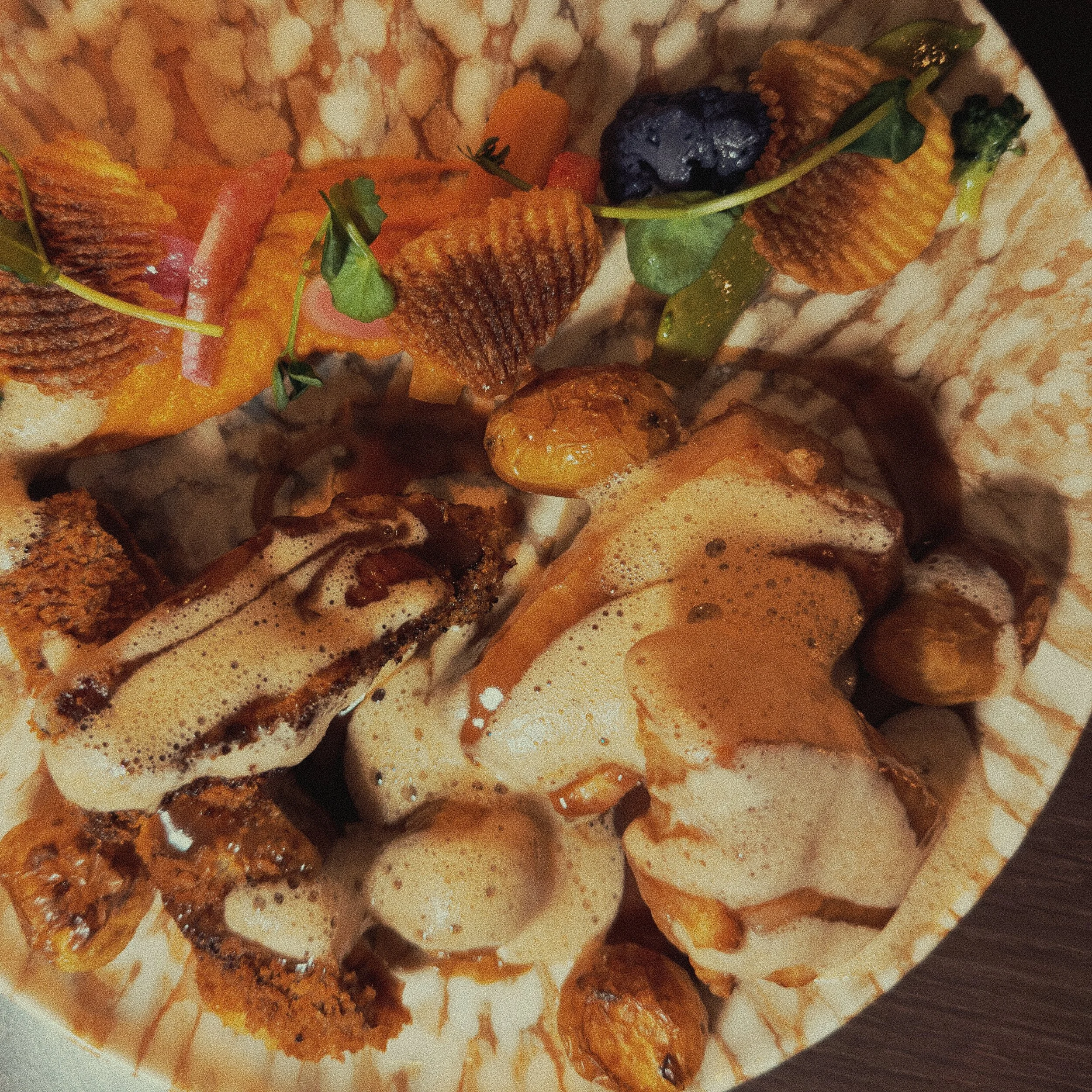 Plat avec différentes décorations, notamment des fruits, des noix et du chocolat, présenté sur un plateau.