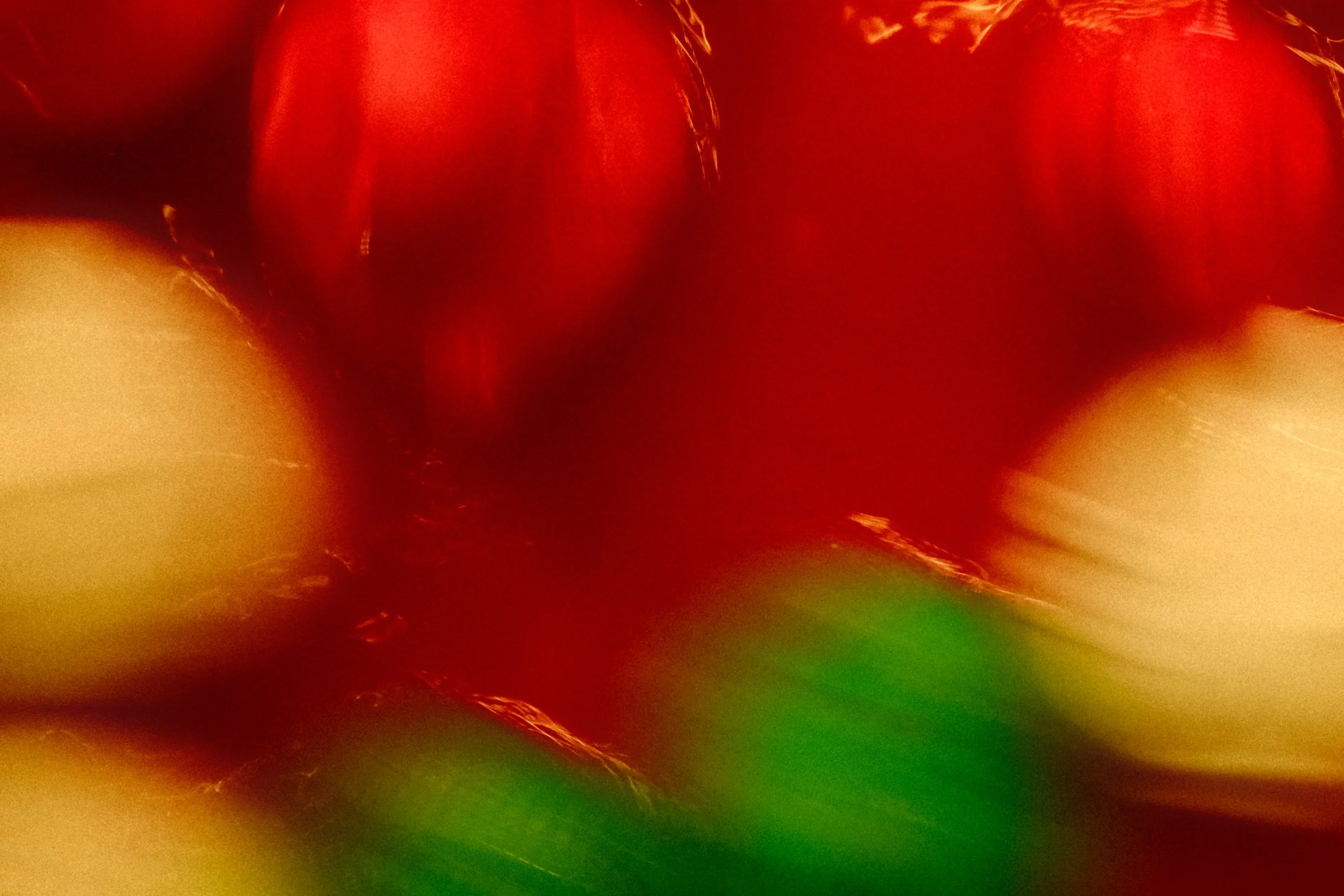 Image floue montrant des jeu de canard (rouge, jaune et vert) au marché de noël. La photo semble être prise à proximité ou en mouvement rapide, ce qui crée une apparence floue.