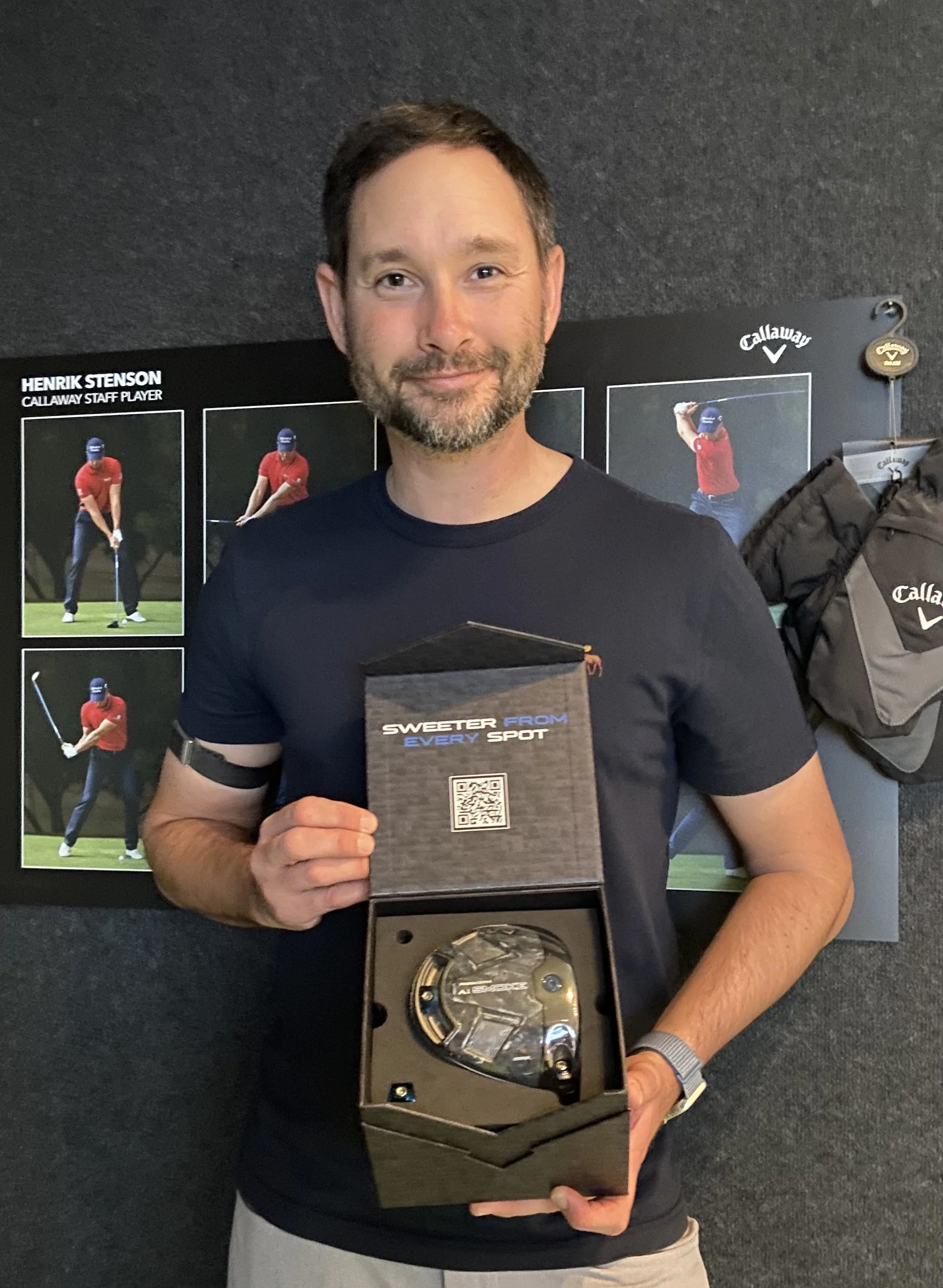 Sebastian Heijdenberg hält eine Uhrenauszeichnung vor einer Ausstellung zu Henrik Stenson.
