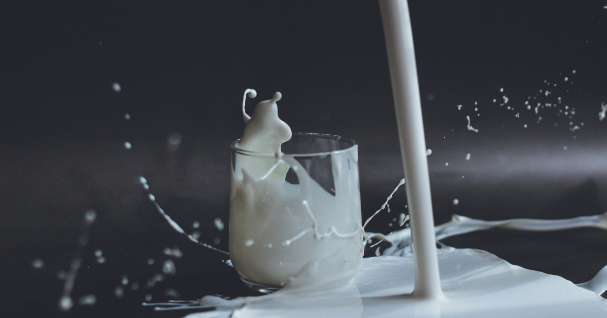 milk pouring into glass and splashing everywhere