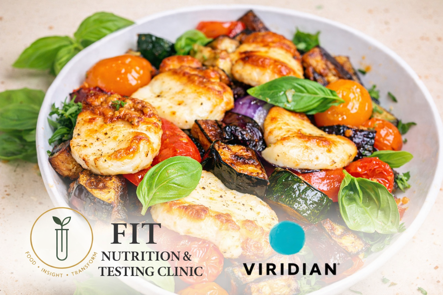 Halloumi and aubergine traybake with roasted cherry tomatoes, courgette and red pepper, topped with fresh basil leaves in a white bowl