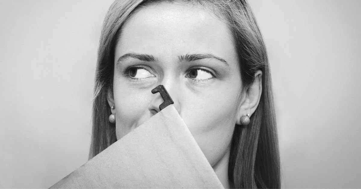 black and white imag eof woman holding a folder to cover her mouth
