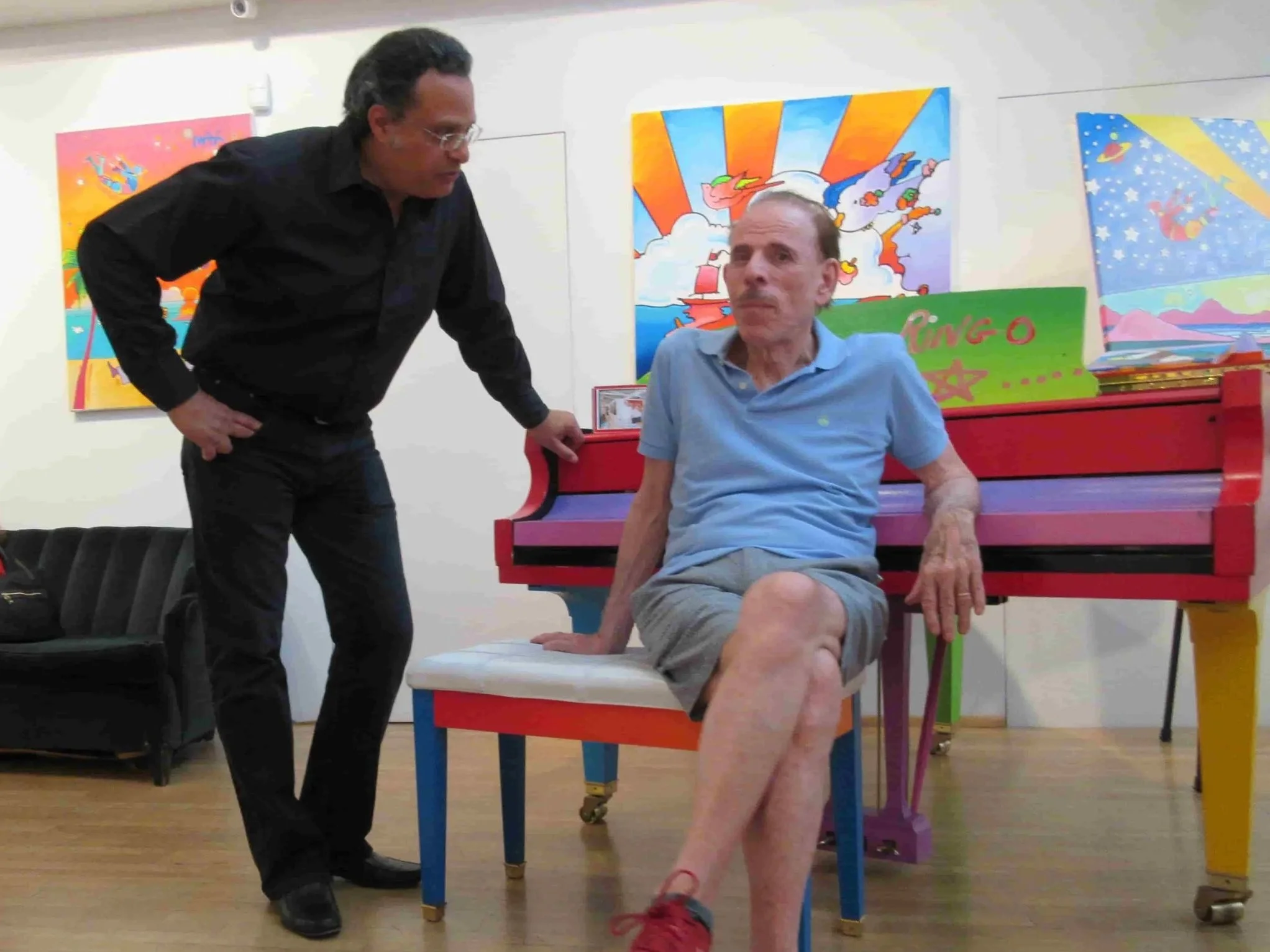 The artist ZARUM with the artist Peter Max in his New York Studio next to a painted piano that was painted by Peter Max and signed by Beatle drummer Ringo Star.