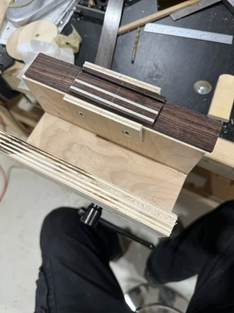 The bridge blank in a jig ready to take on the shape using a file