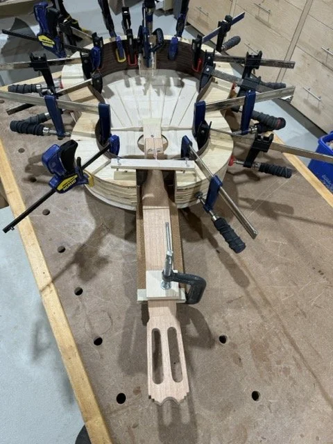 The guitar neck is clamped onto the solera and glued to the sound board