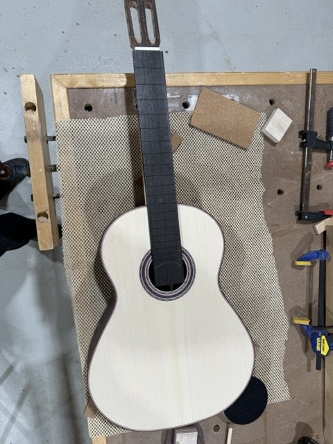Fret board slotted and adhered to the neck with the nut at the top of the neck showing
