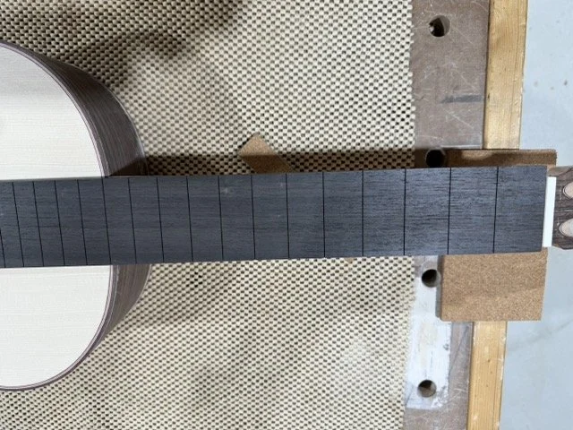 Fretboard slotted and adhered to the neck