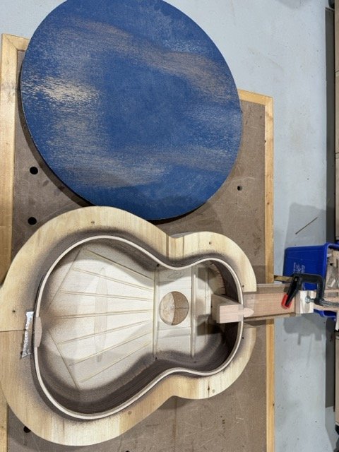 Using a large round sandpaper disk which has a 25 foot radius to it, the sides are sanded to form the proper angle in which to glue the back to