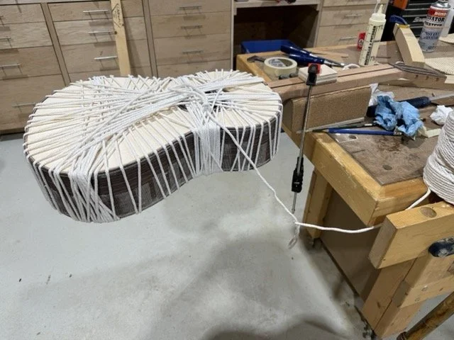 The front and side binding strips are glued and held in place to dry using the traditional method of wrapping a large diameter cotton string around the body as the strips are glued working all the way around the body