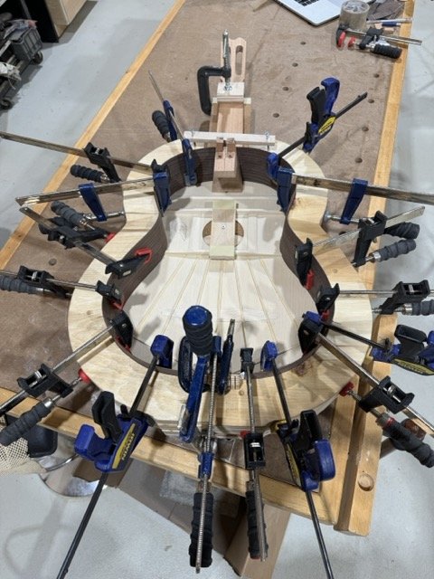 The guitar is ready to receive the small triangular Spanish cedar pieces known as 'piones' which are glued to the soundboard and the sides bonding them together