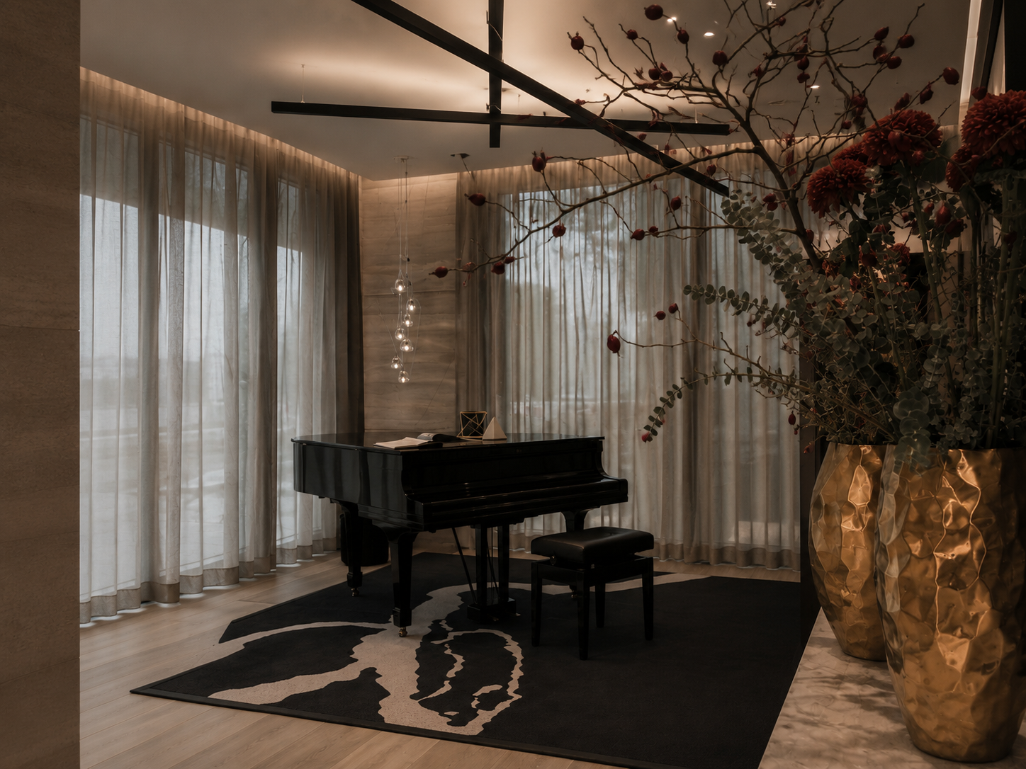 Atelier Onyx - stilvoll eingerichtete Lobby mit einem schwarzen Klavier, einem passenden Stuhl, großen Fenstern mit Vorhängen, einem schwarzen Teppich mit einem Tiermotiv und einer großen goldfarbenen Vase mit einer Blumen- und Zweigdeko.