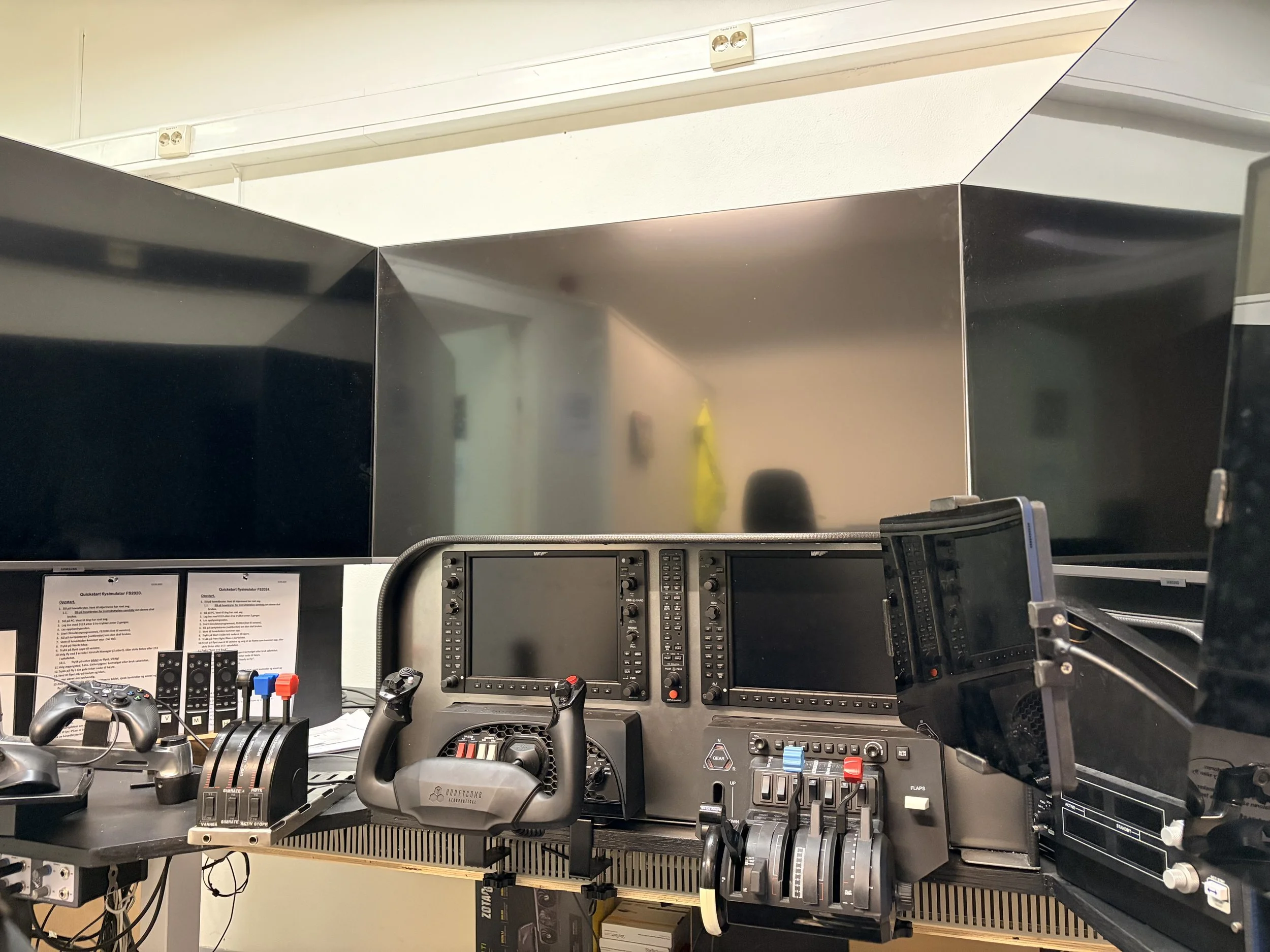 Aircraft cockpit control station with multiple monitors, control yoke, and instrumentation.