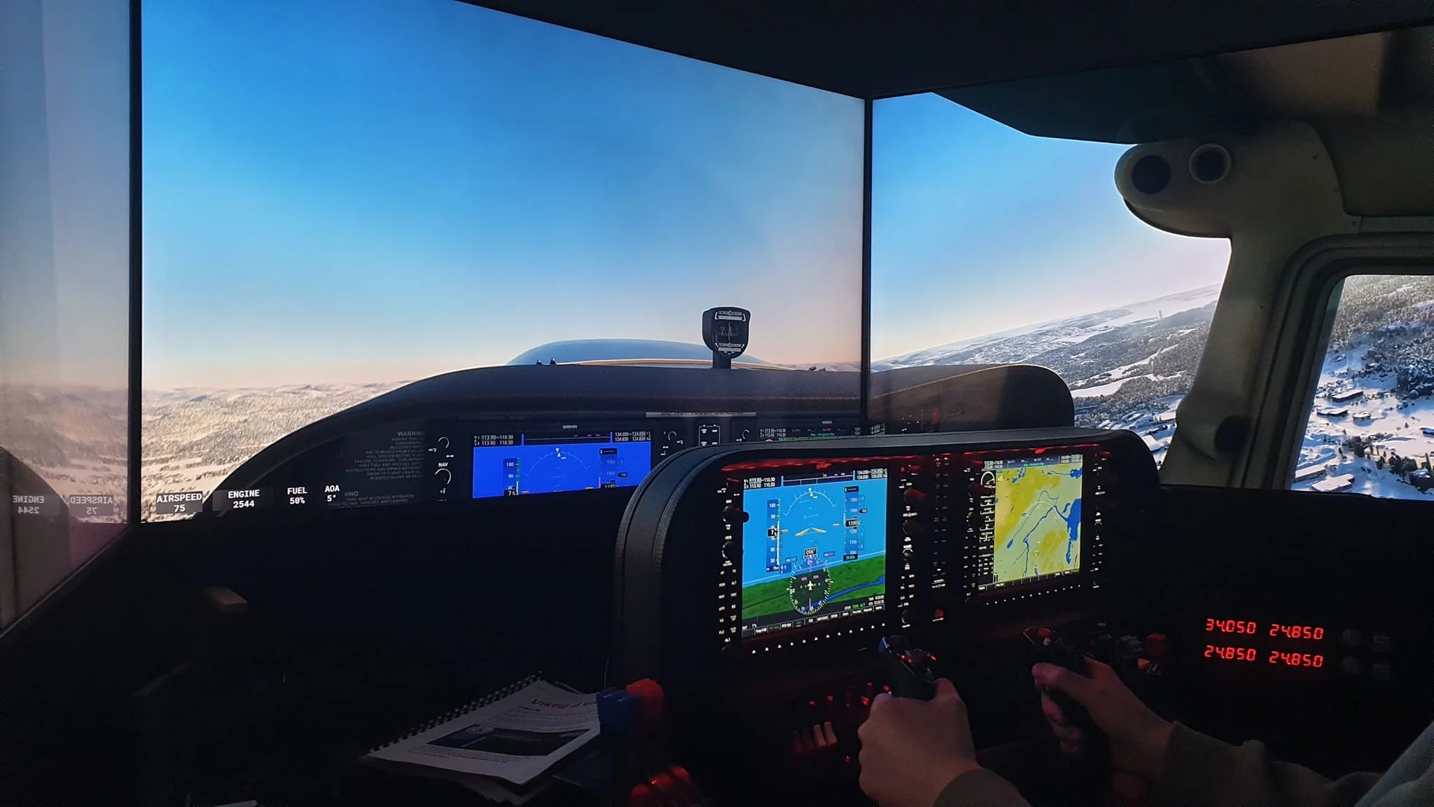 Inside view of an airplane cockpit with digital displays, pilots' hands on controls, flying over snowy mountains.