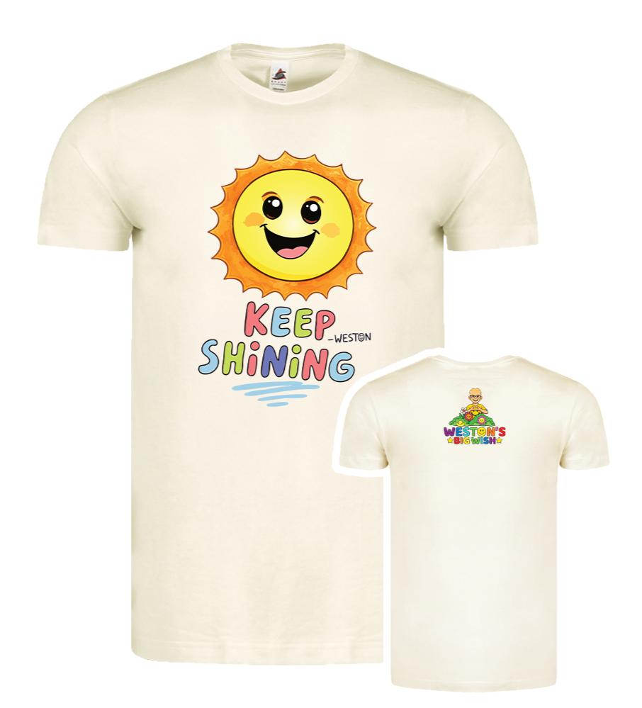Cream-colored T-shirt featuring a cartoon sun with a smiling face and the phrase 'Keep Shining' on the front. The back of the shirt displays a colorful graphic of a character with sunglasses and the words 'Weston's Big Wish'.
