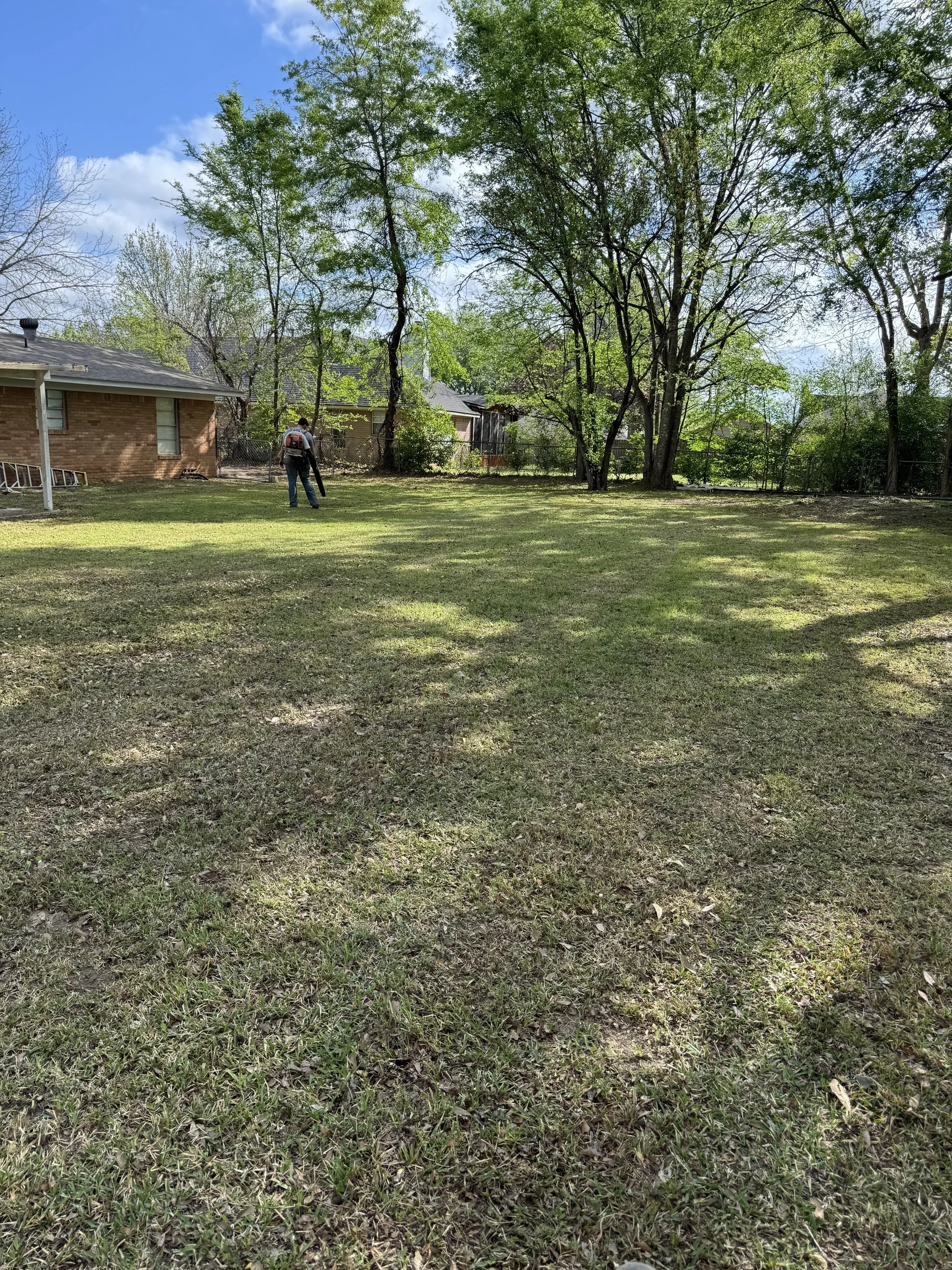 5h services employee doing yard maintenance on residential area.