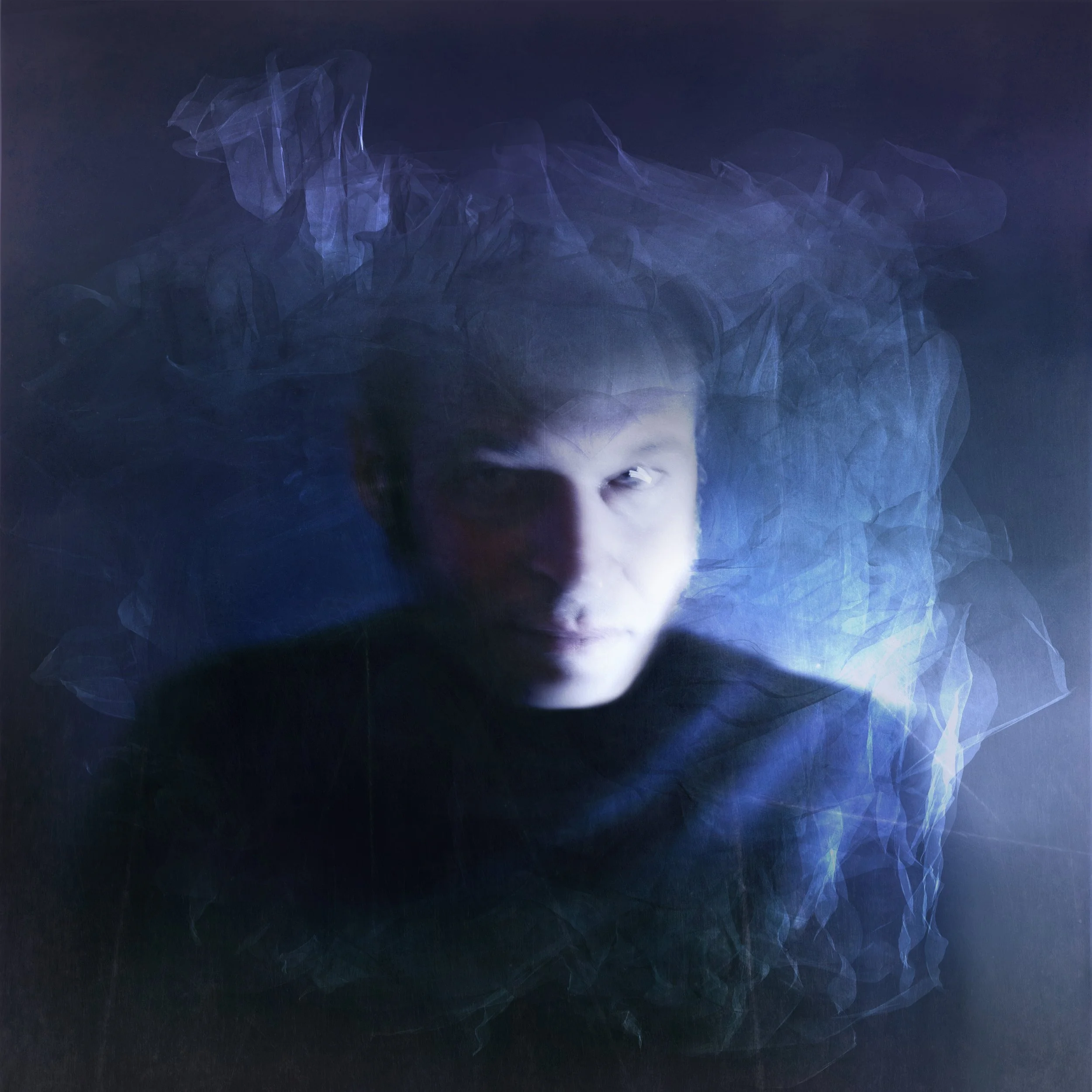 Album cover for Jes Harris's new album, Expand. A portrait of a the artist with a serious expression, surrounded by wisps of blue and purple smoke or light, creating a mysterious and surreal atmosphere.