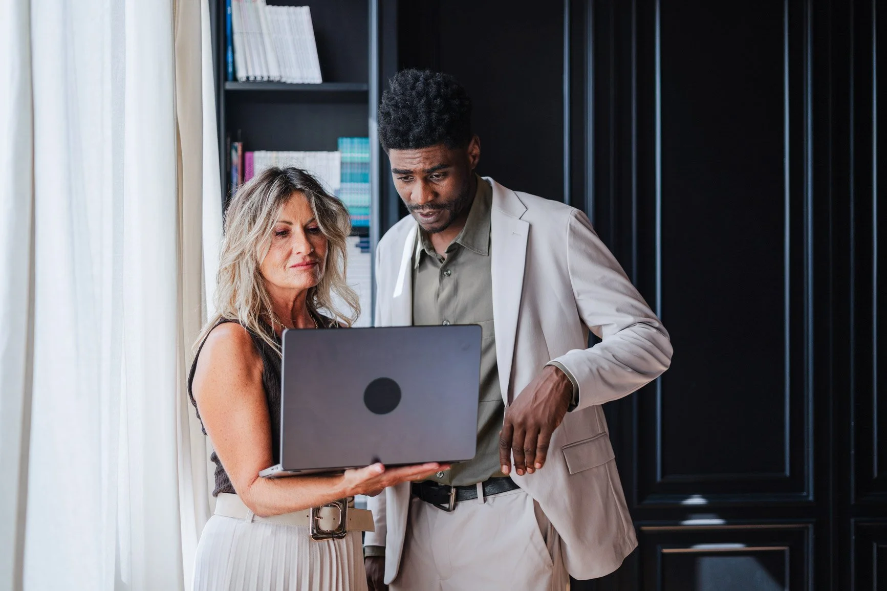 HR advisor guiding a client through information on a laptop.