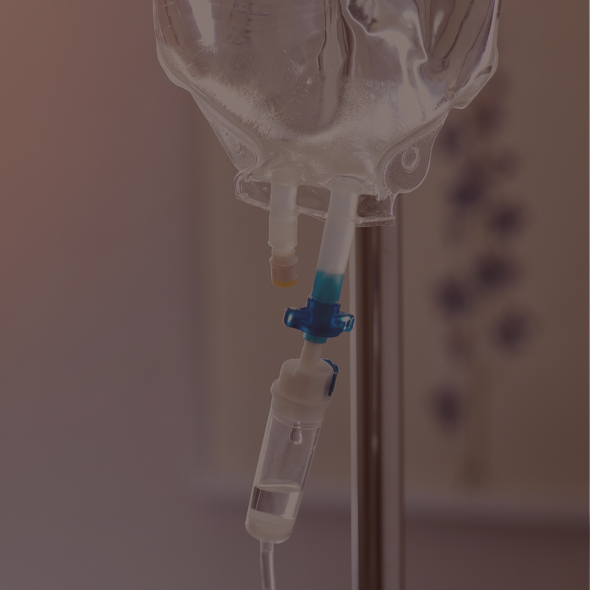 Close-up of a medical intravenous (IV) drip and tubing, with a blurred background.