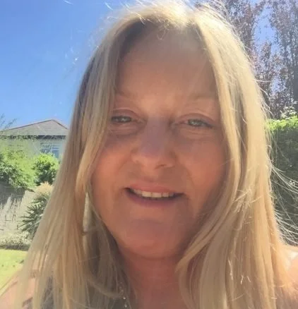 A doctor of sports therapy and physiotherapy. the headshot shows a woman with long blonde hair smiling outdoors in bright sunlight.