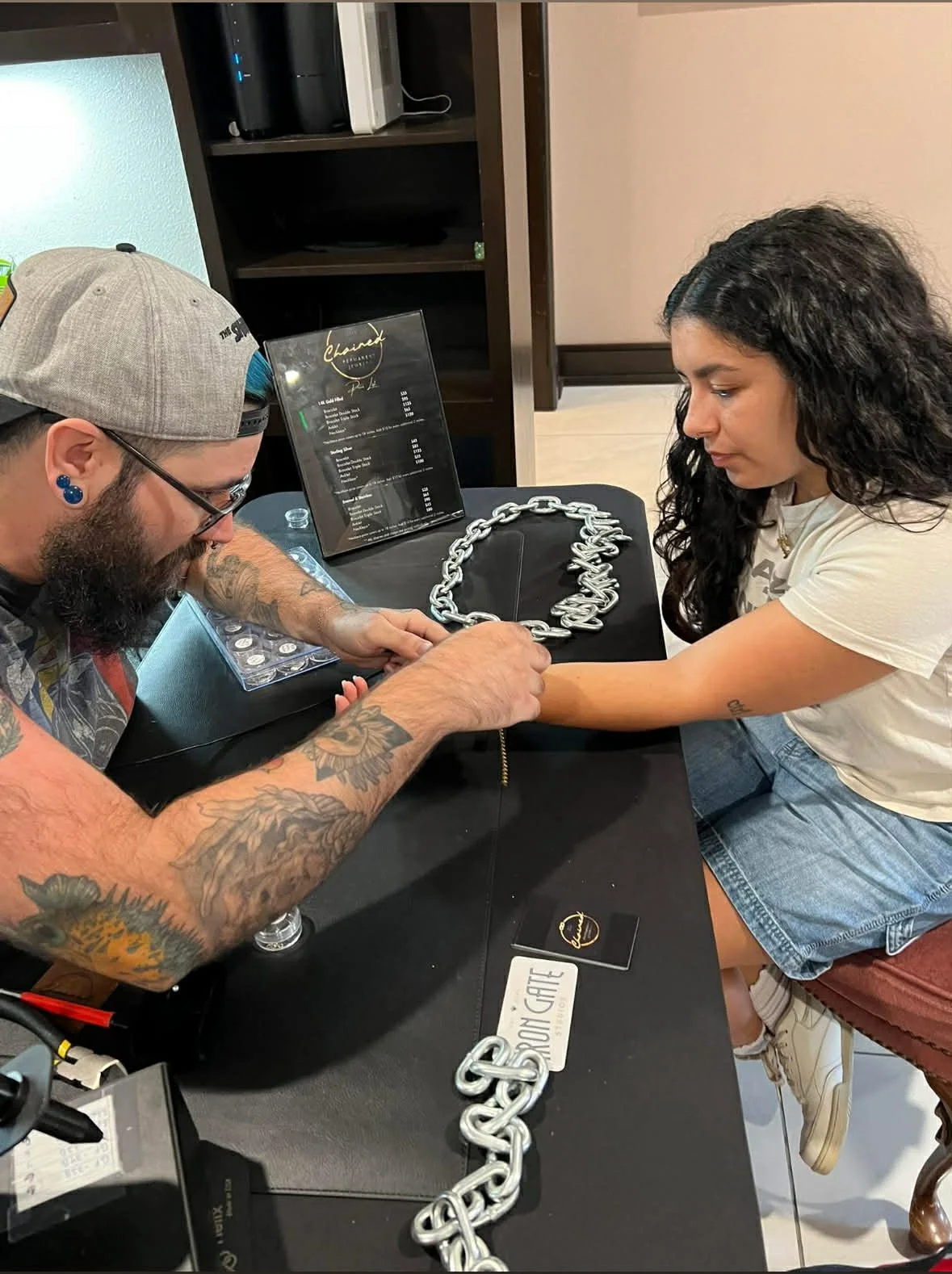 Tattoo artist showing jewelry to client at a jewelry shop