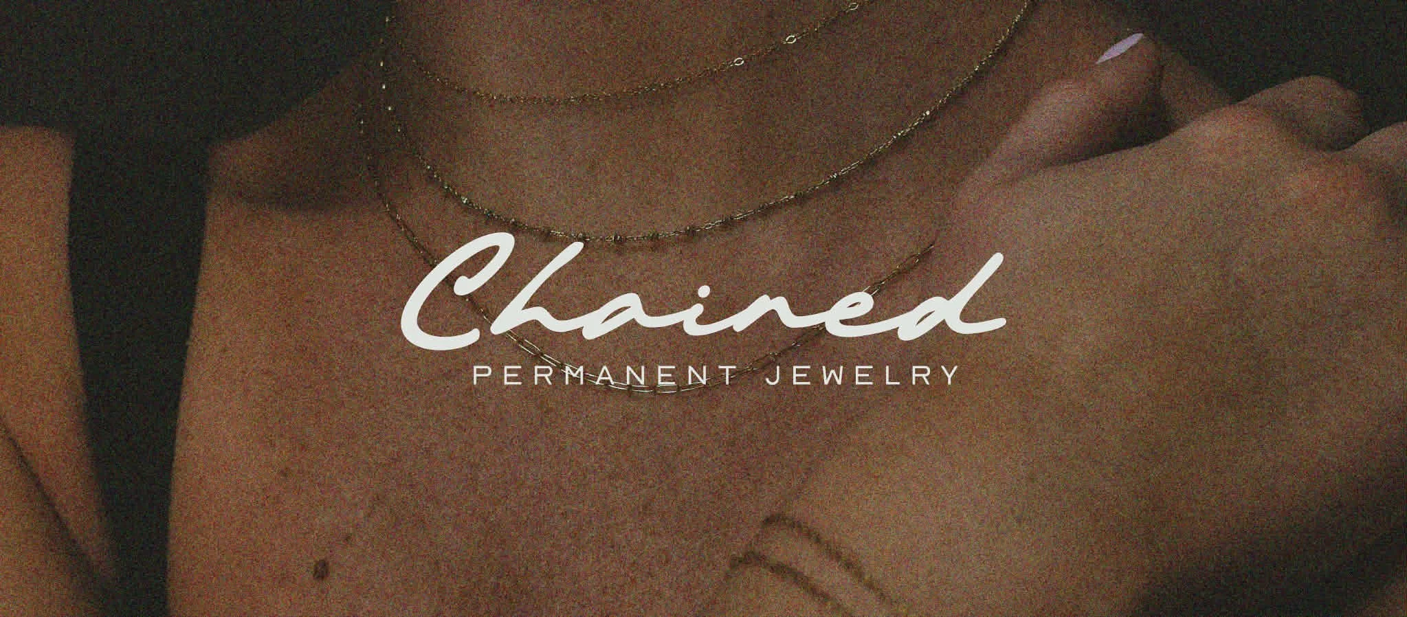 Close-up of a woman's neck and chest adorned with layered gold necklaces, with a logo reading 'Chained Permanent Jewelry' overlaying the image.