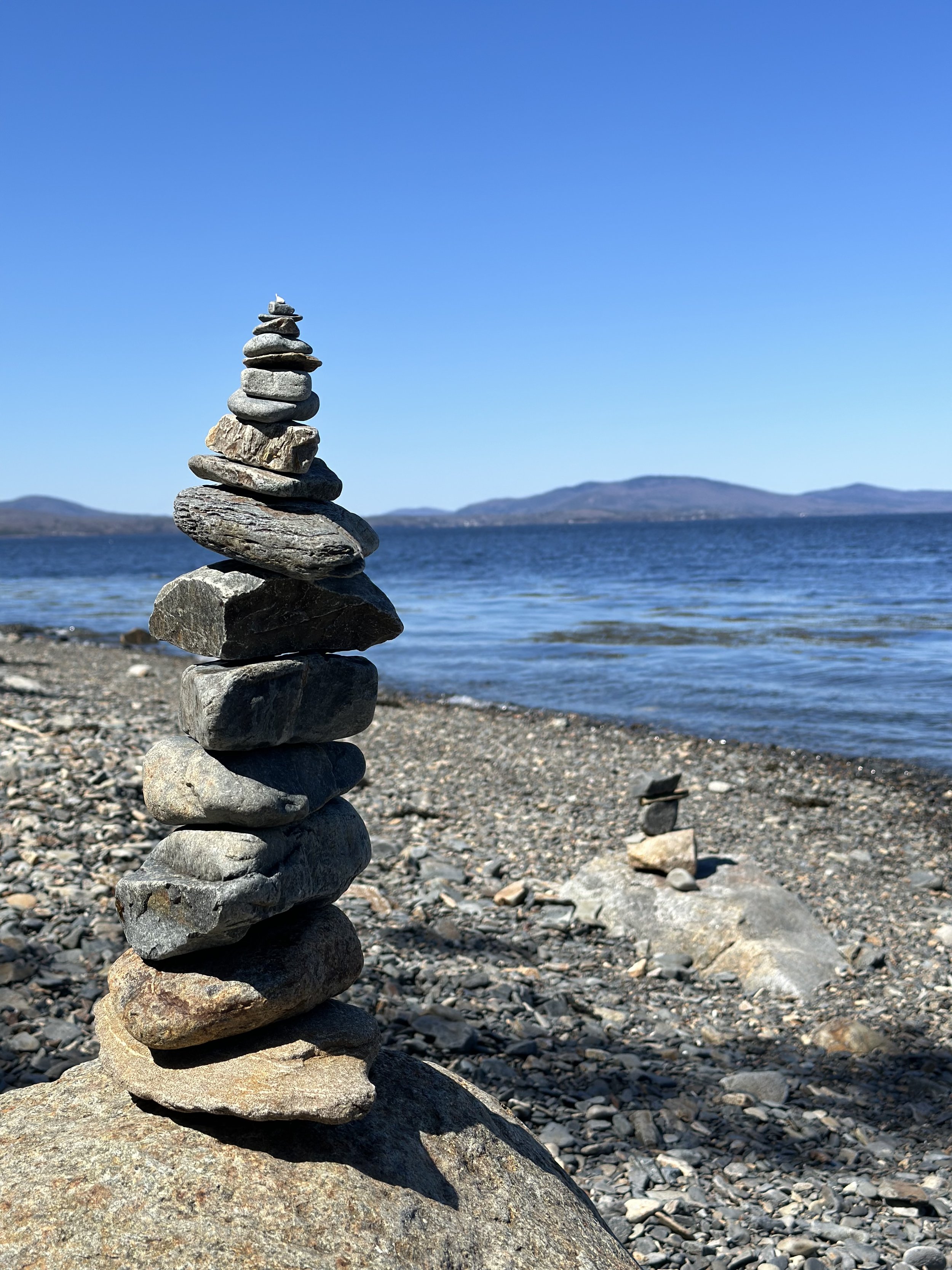 A gorgeous view of Rockland Harbor from the Owls Head State Park with fun stacked rocks in an iconic way