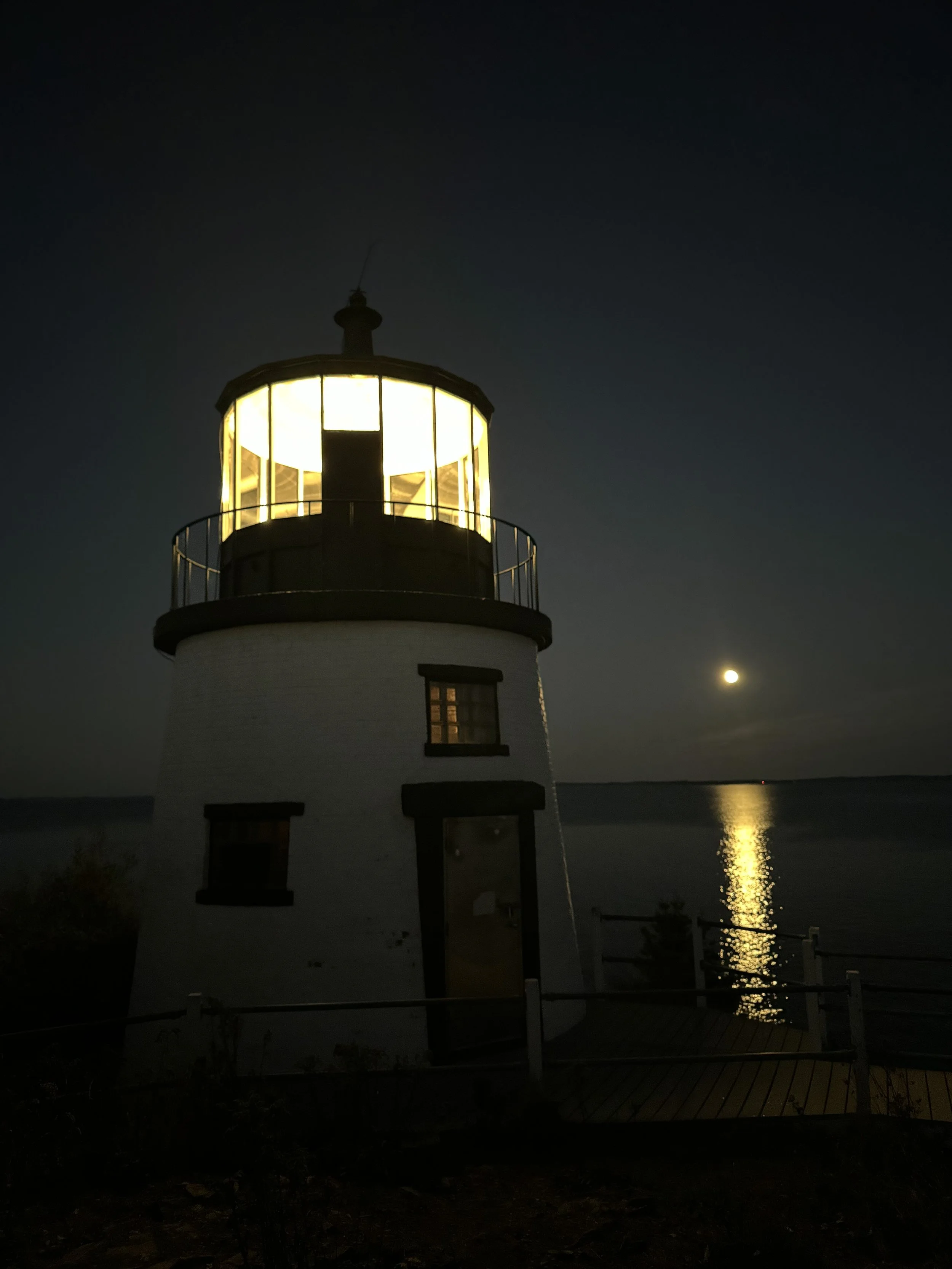 A breathtaking view of Owls Head light at the Owls Head State Park at night with a full moon rise