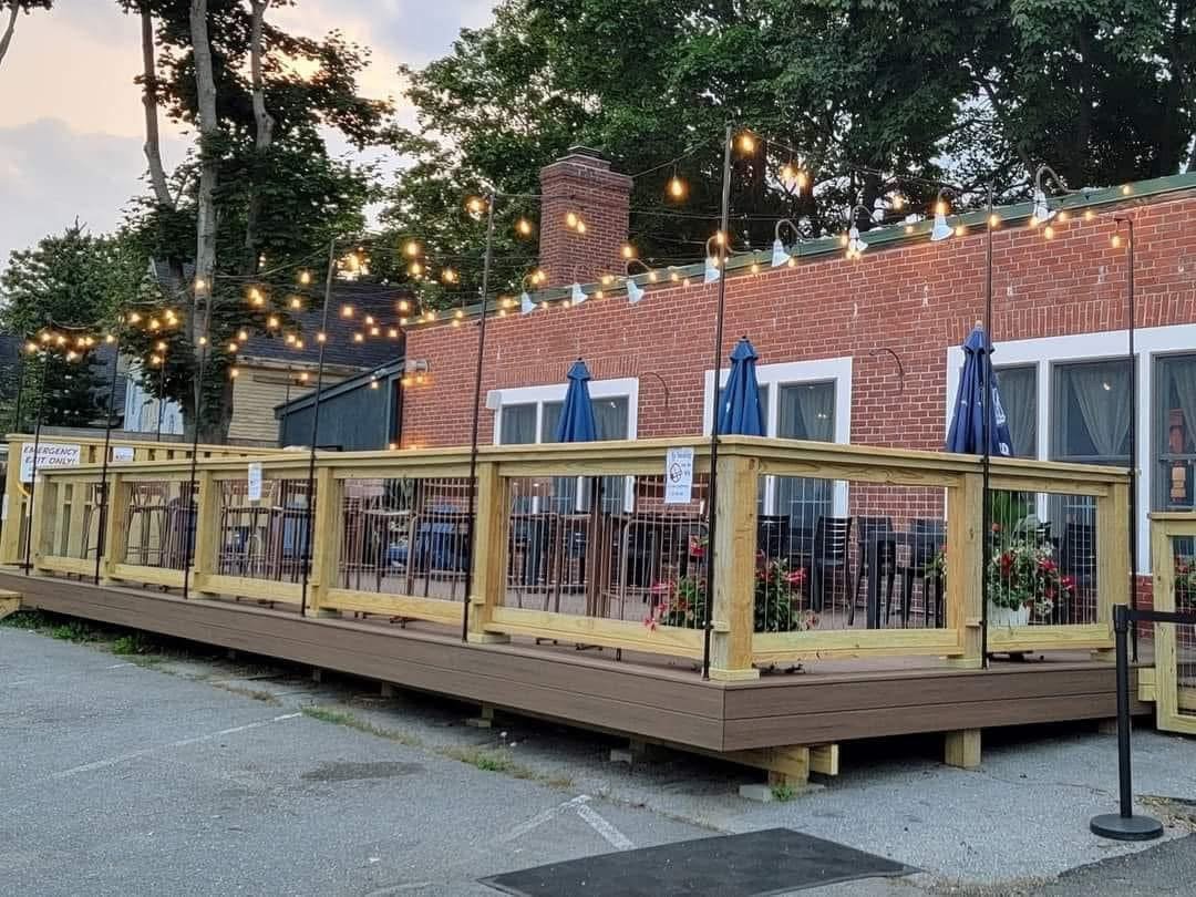 a beautifully illuminated spacious outdoor patio with gorgeous lights and twinkle lights, gorgeous flowers for a perfect ambience here at the waterworks restaurant and pub - rockland maine