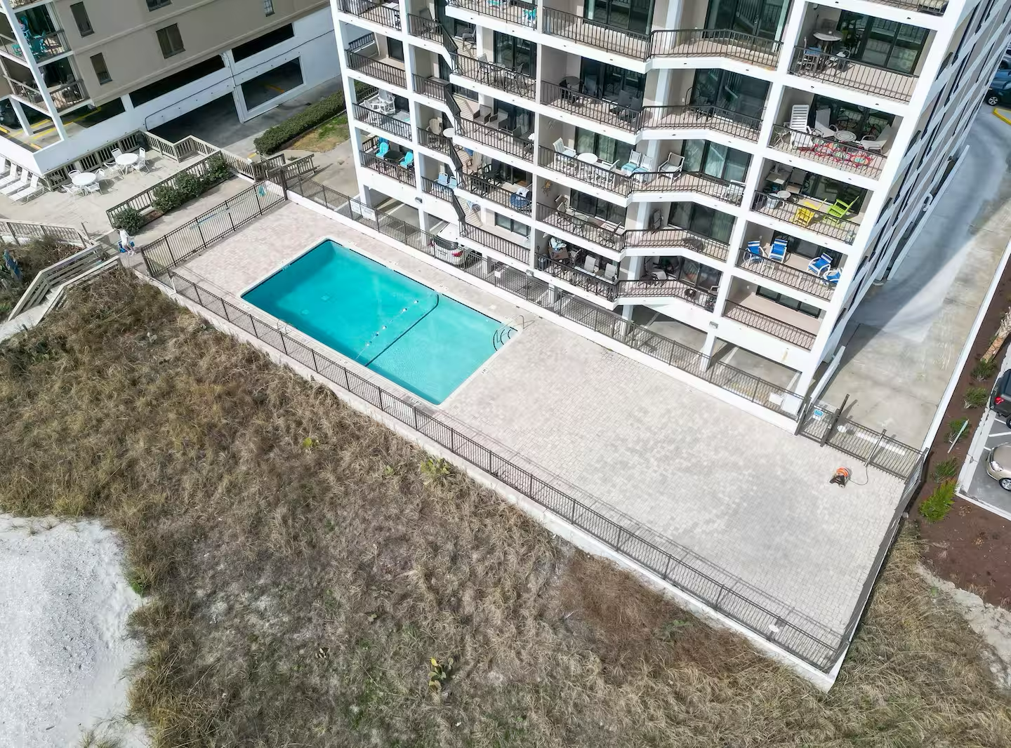 You'll love unwinding by the sparkling blue pool, perfectly positioned within the peaceful courtyard of your vacation home. Step out onto your private balcony and soak in this serene view.
