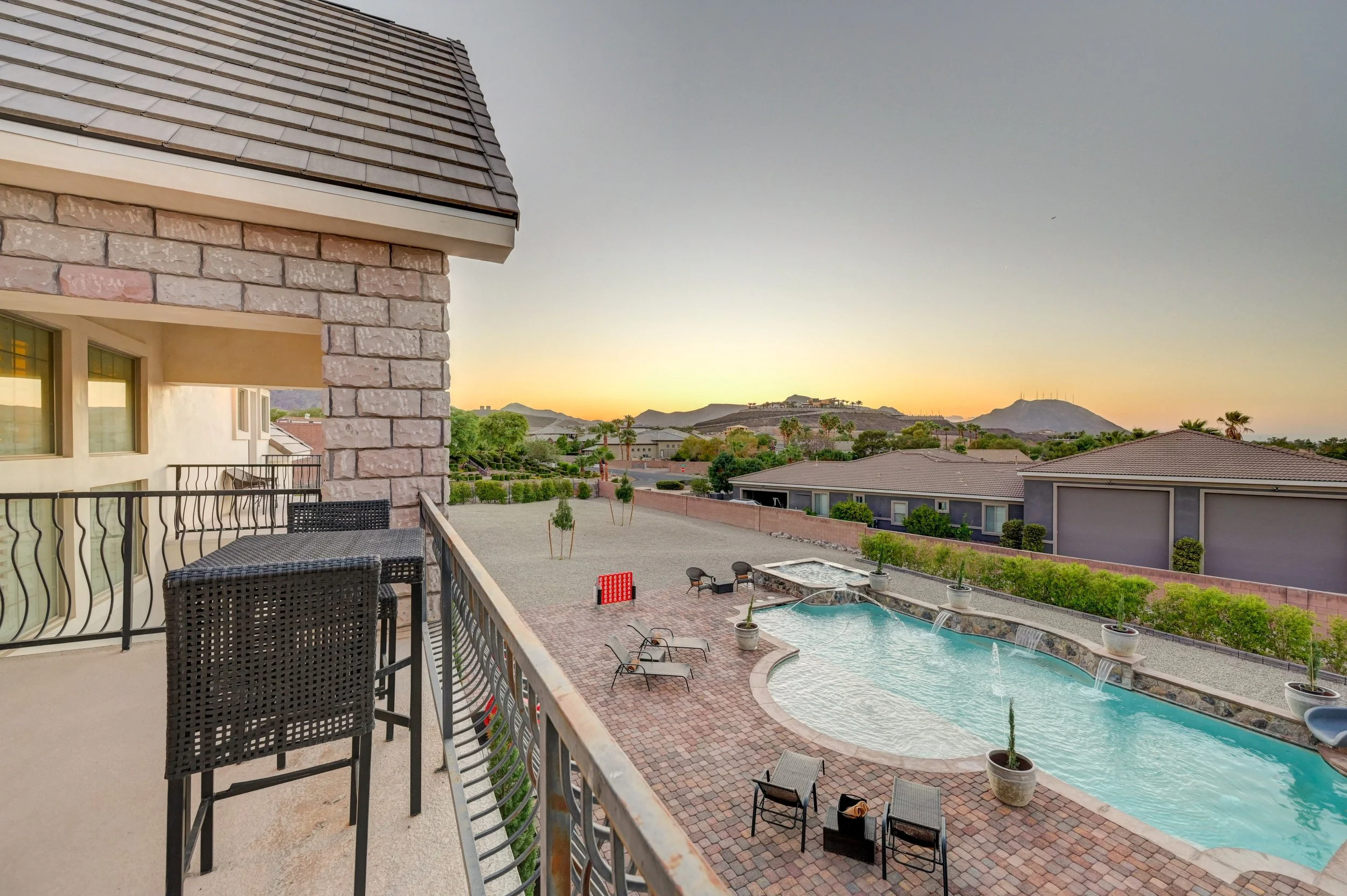 Grand balcony with views of the mountains, Las Vegas Strip fireworks, and pool at The Castle private estate in Henderson, 