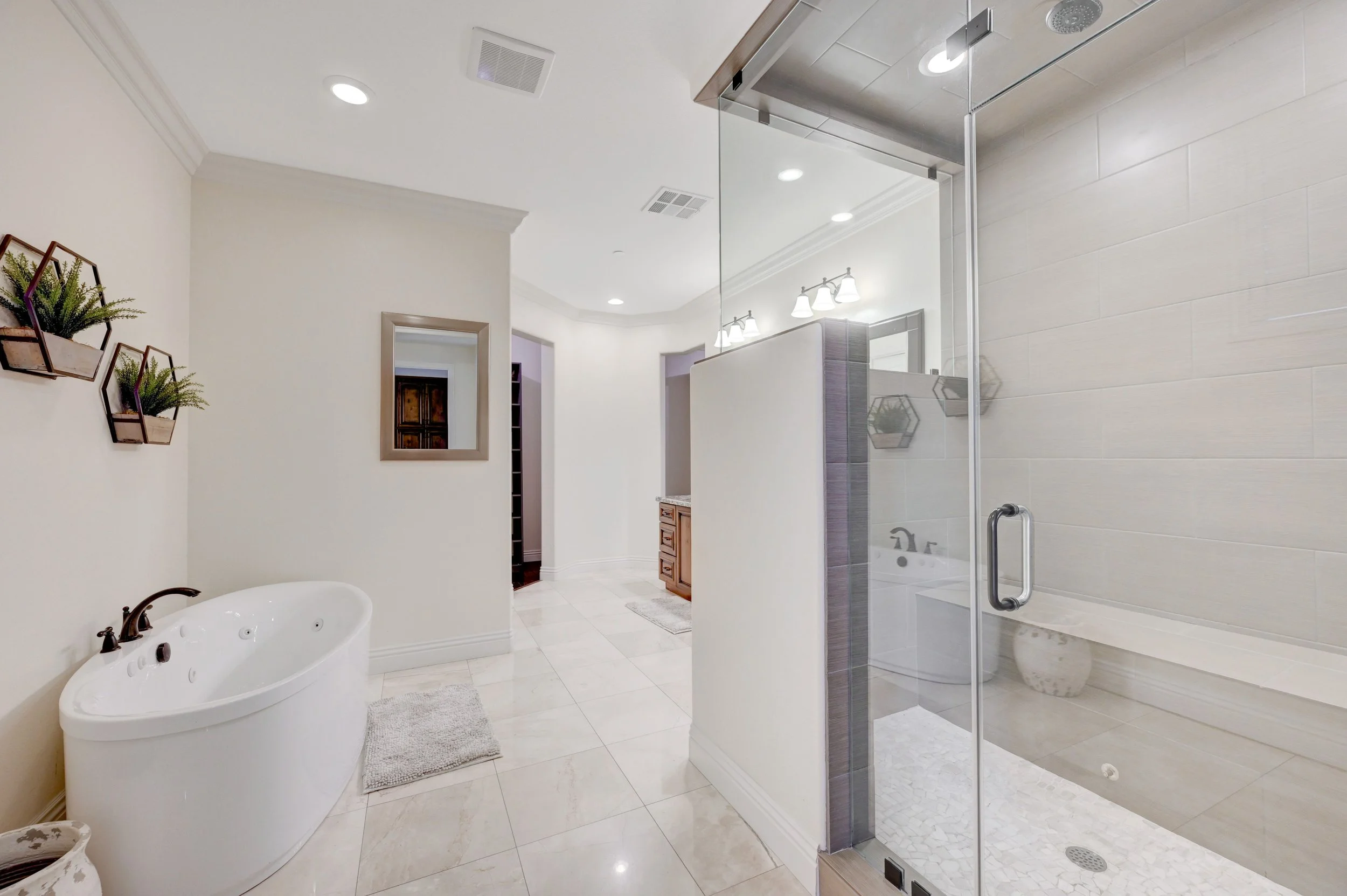 Primary suite en-suite bathroom with jacuzzi soaking tub and glass walk-in shower at The Castle private estate in Henderson, Nevada