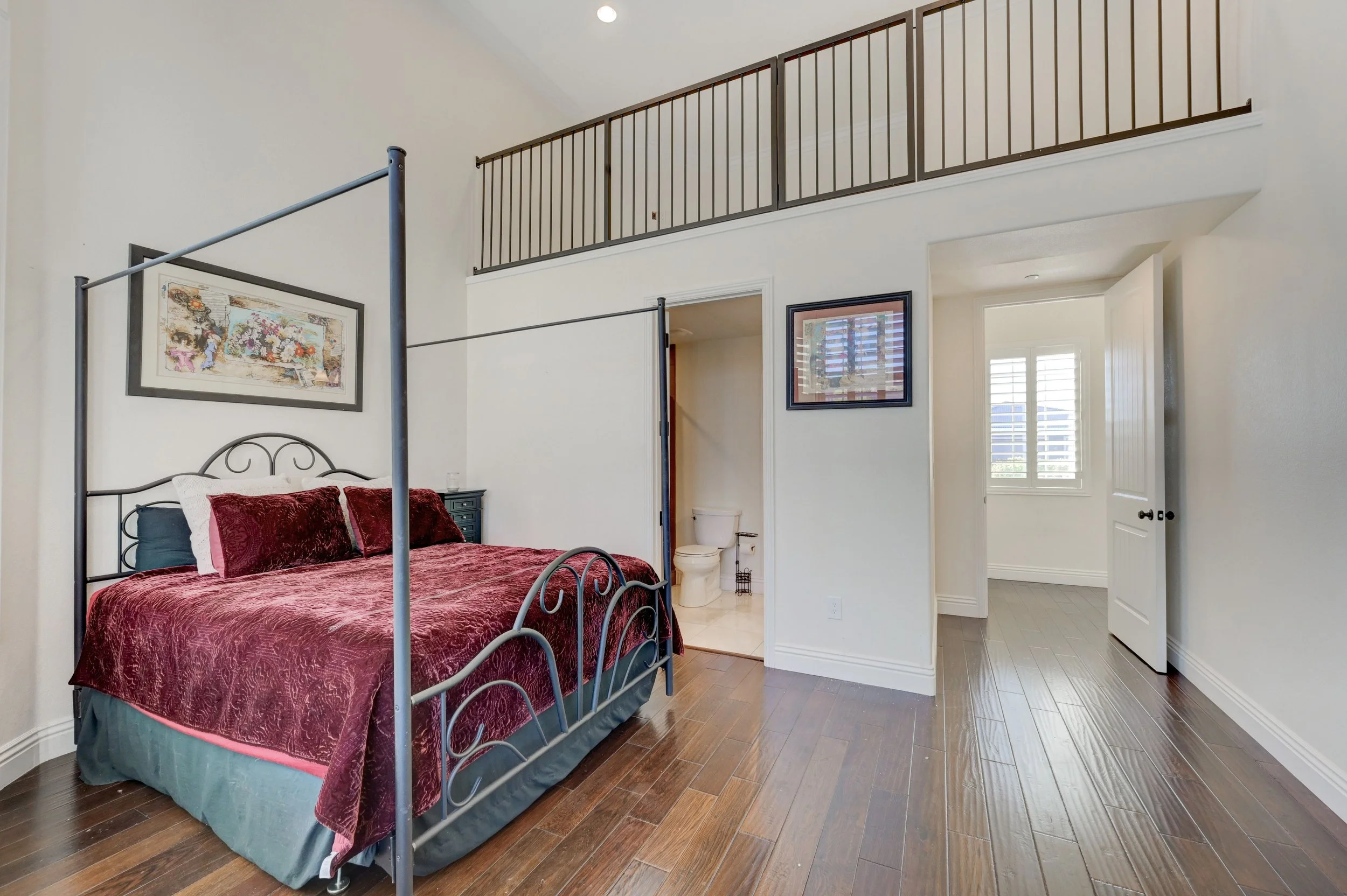 Loft bedroom with en-suite bathroom and 28-foot wall-to-wall windows with adjustable plantation shutters at The Castle luxury vacation rental in Henderson near Las Vegas