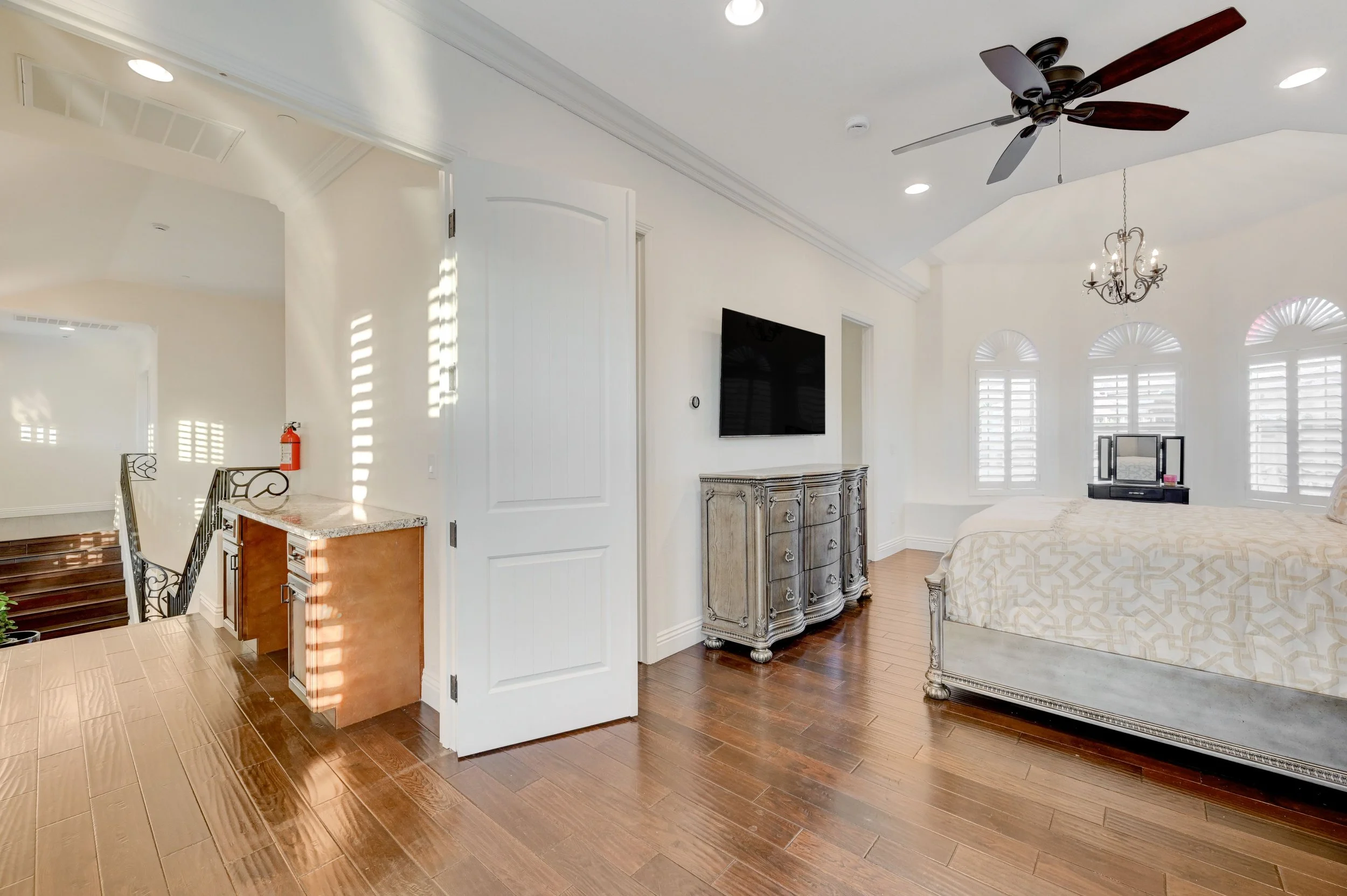 Tower 2 suite with queen bed, two bunk beds, en-suite bathroom, wraparound windows with mountain views, and grand balcony overlooking the Las Vegas Strip and pool at The Castle luxury vacation rental in Henderson