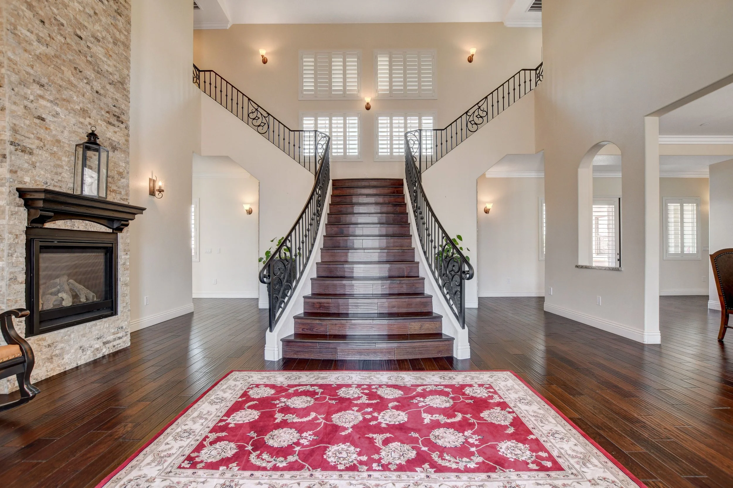 Grand entry foyer with soaring ceilings, fireplace, and sweeping staircase at The Castle luxury vacation rental in Henderson near Las Vegas