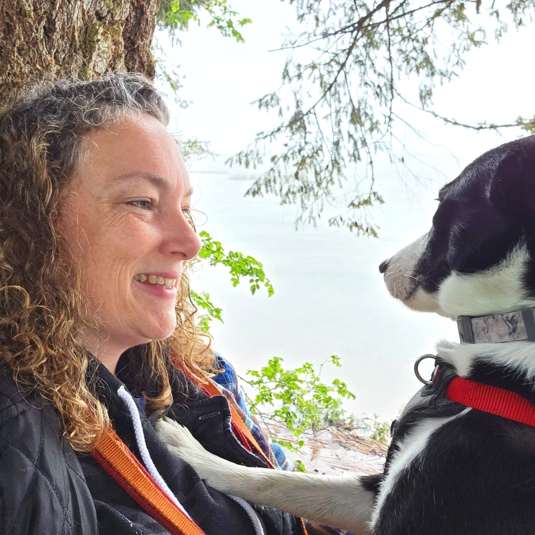 Sara the main trainer and owner of Barkasana Dog Training and Yoga Classes is outside smiling getting ready to train dogs with virtual dog training with Barkasana with Doja the Border Collie 