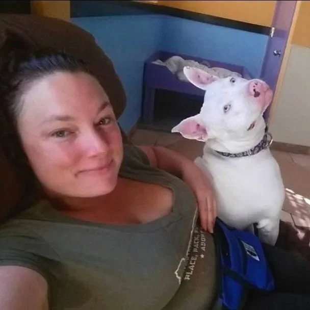 Sara the main trainer and owner of Barkasana Dog Training and Yoga Classes is outside smiling getting ready to train dogs with virtual dog training with Barkasana while at a dog rescue 