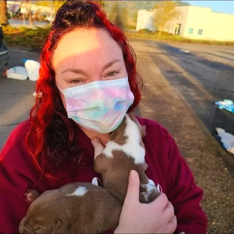 Sara the main trainer and owner of Barkasana Dog Training and Yoga Classes is outside smiling getting ready to train dogs with virtual dog training with Barkasana and transport rescue puppies 