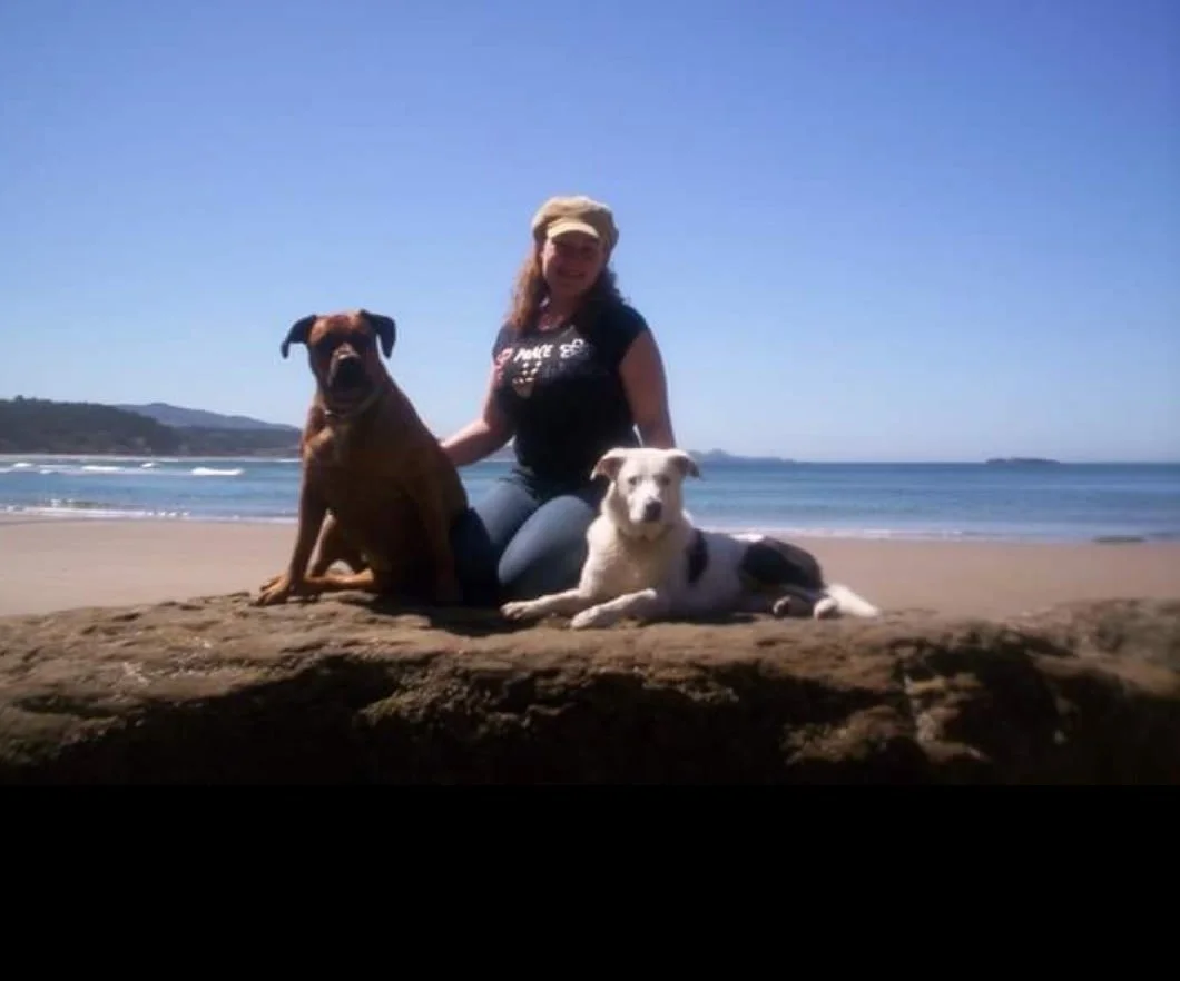 Sara the main trainer and owner of Barkasana Dog Training and Yoga Classes is outside smiling getting ready to train dogs with virtual dog training with Barkasana at the beach 