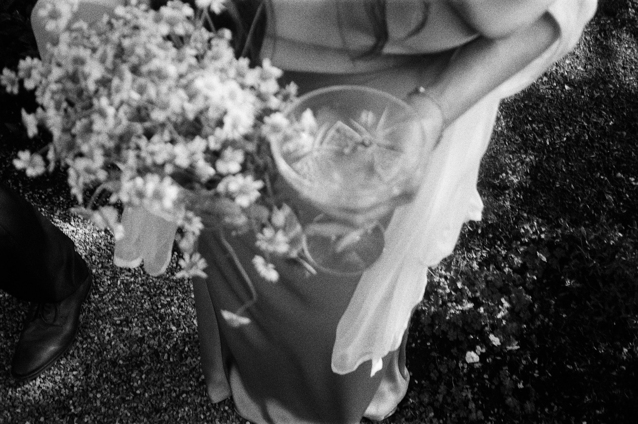 Top-down view of a mother at a wedding holding a coup glass with flower garnish by Mendocino Outland bartending. Switzerland Farm, Mendocino. 