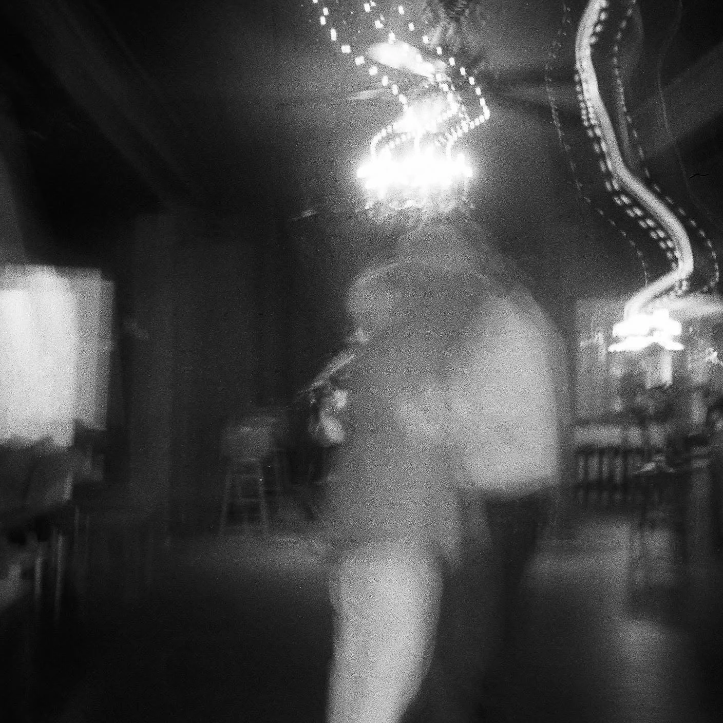Blurred black and white photo of an older couple dancing to live music, my girl,  hanging string lights and a chandelier, heritage house little river ca. 