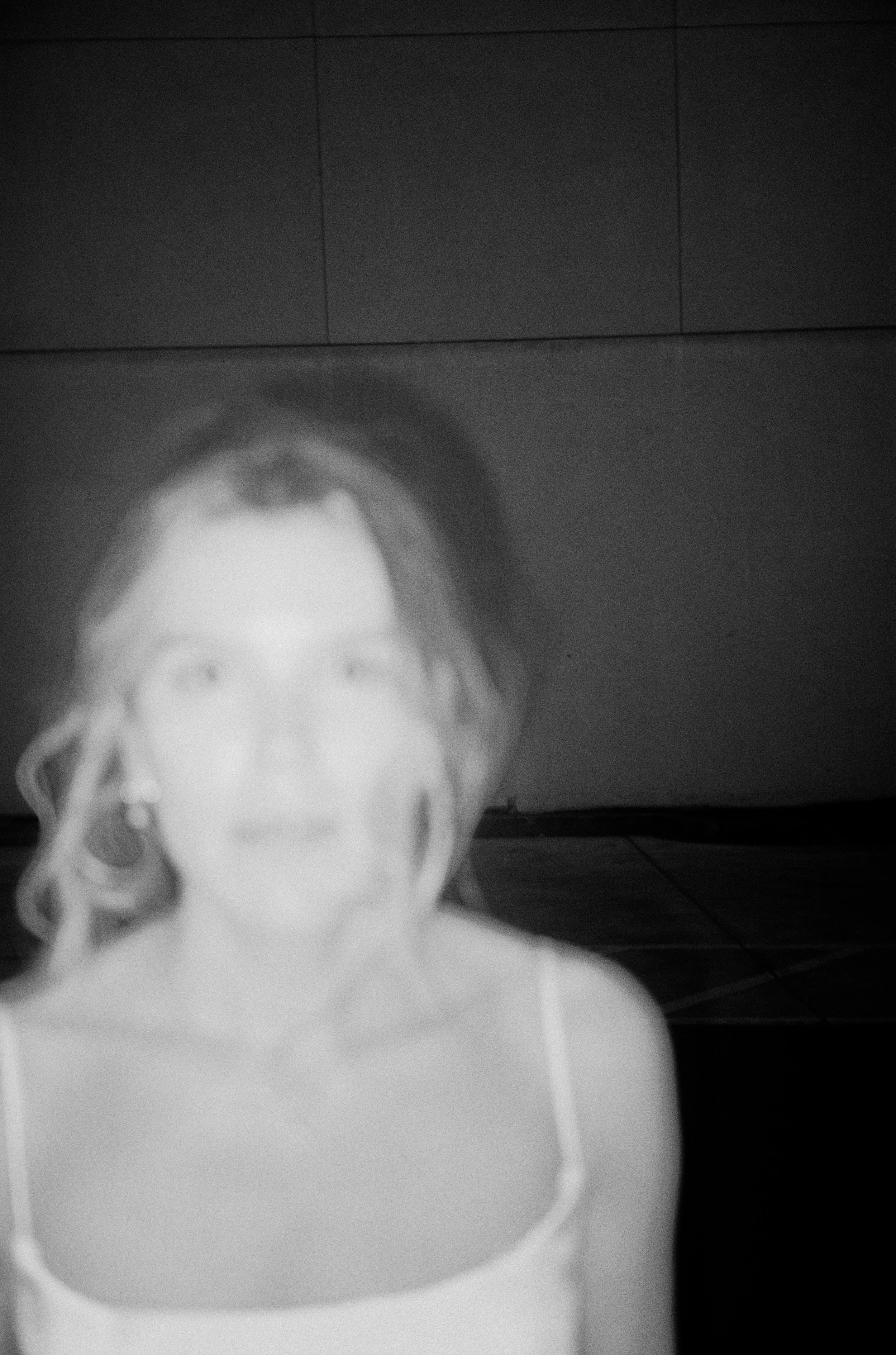 A woman standing outdoors at night, blurred image with a dark sky and a distant horizon. Film, Berkeley elopement. 
