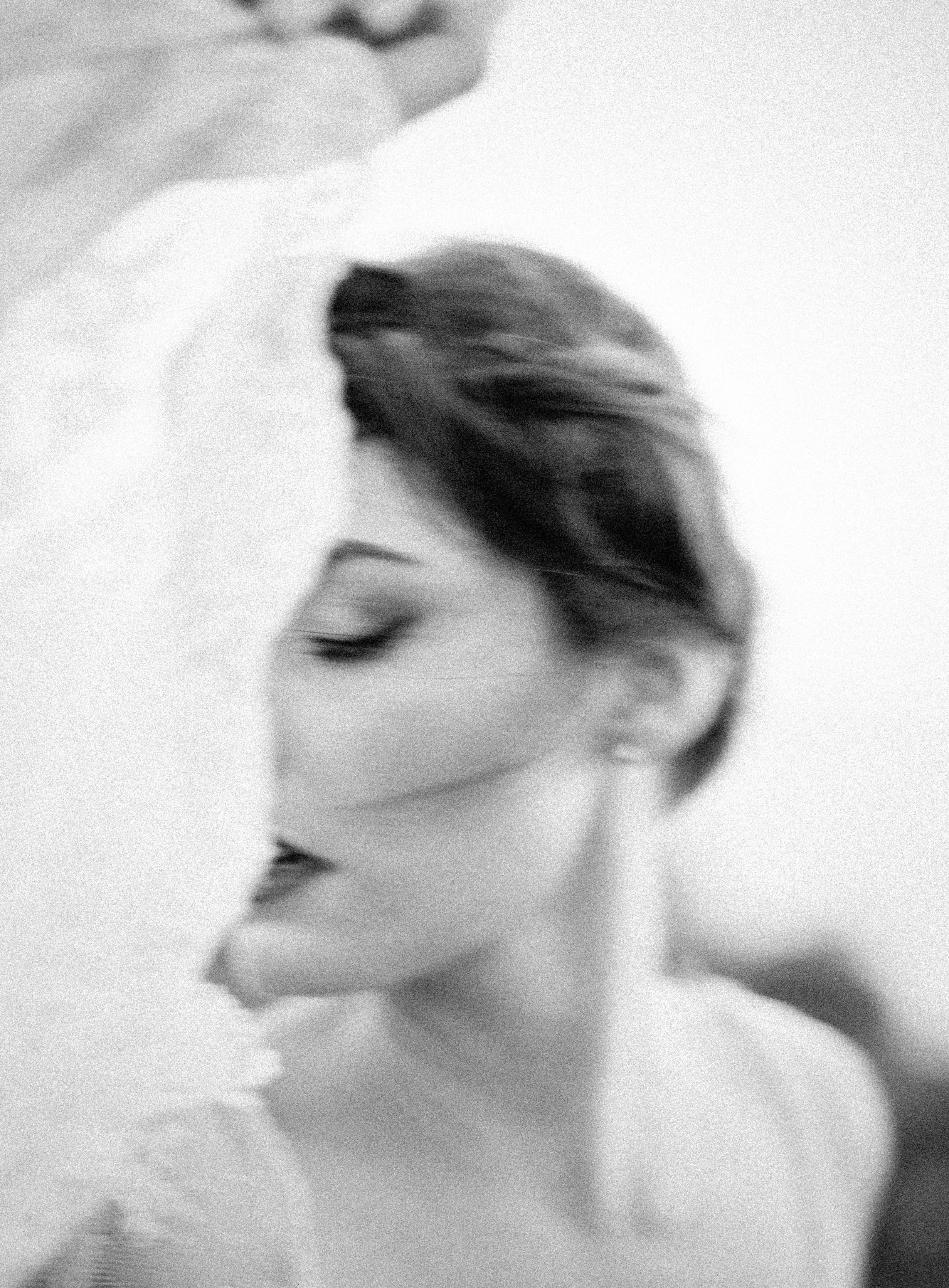 Black and white close-up portrait of a woman with a short hairstyle, eyes closed, in a soft, artistic style. Big Sur California film. 